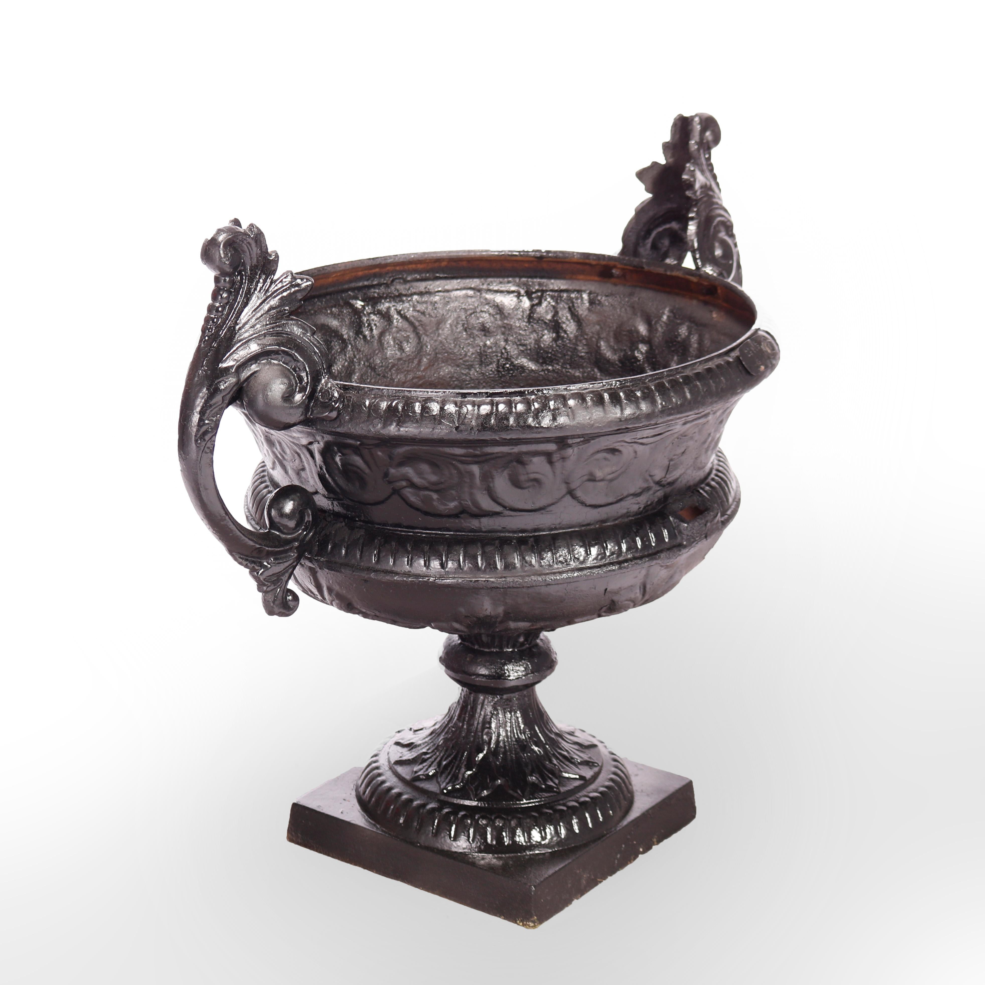 An antique Victorian garden urn offers painted cast iron construction with central planter having scrolled foliate form handle and raised on pedestal base, 19th century

Measures - 25.75''H x 28''W x 21''D.