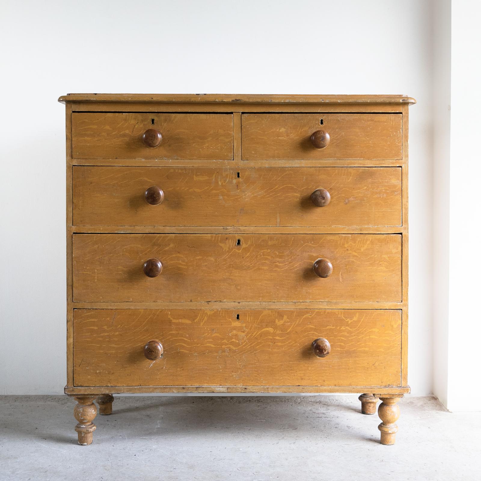 COMMODE ANTIQUE 

Construite en pin avec des poignées tournées et des pieds tournés. 

Deux petits tiroirs sur trois longs tiroirs gradués. 

Dans sa peinture d'origine d'un fond ocre jaune avec un faux grain peint à la main imitant le chêne.