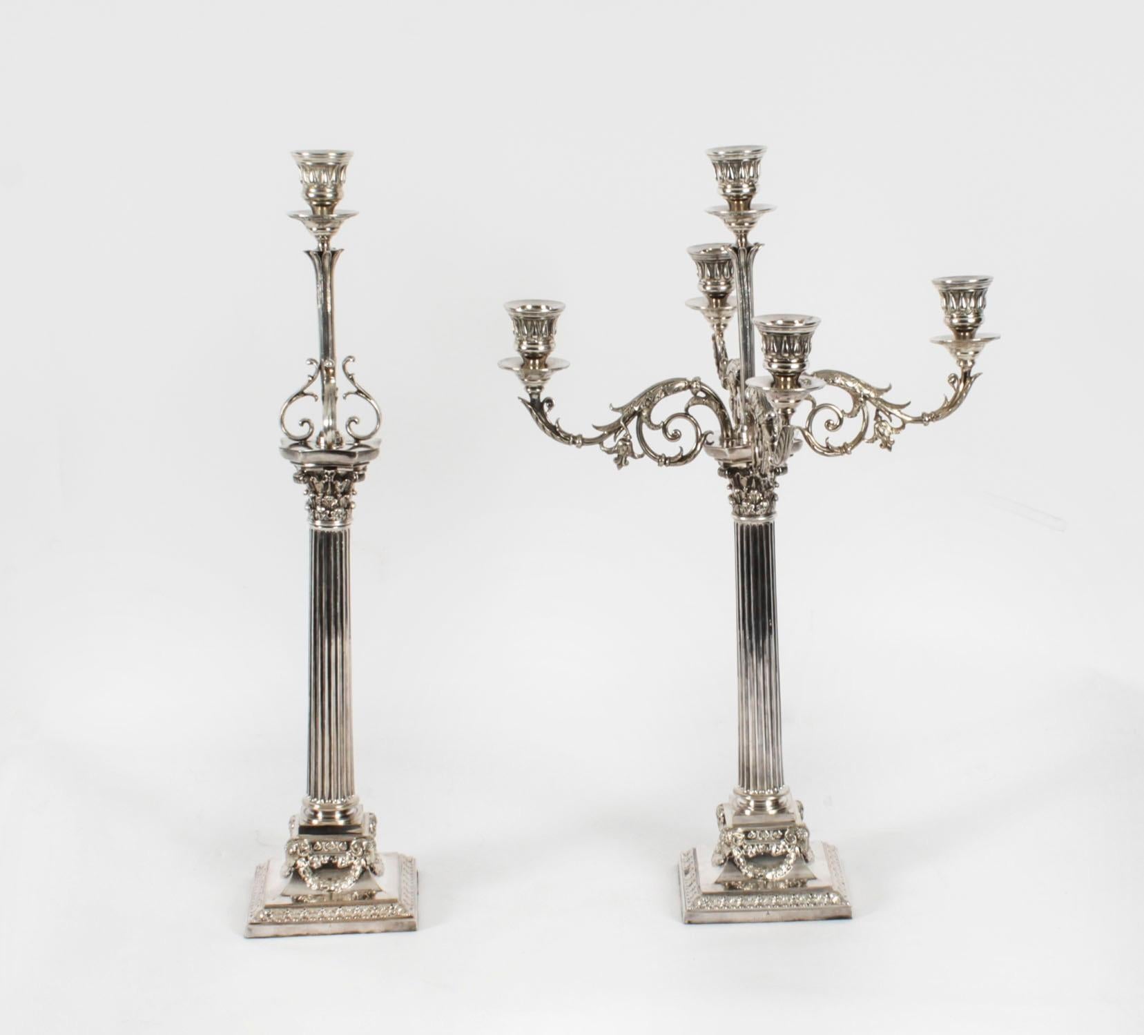 Si tratta di una magnifica coppia di antichi candelabri inglesi vittoriani in argento su rame a tre luci a colonna corinzia, ciascuno dei quali reca il marchio del rinomato argentiere Elkington & Co. e reca marchi impressi con la data del