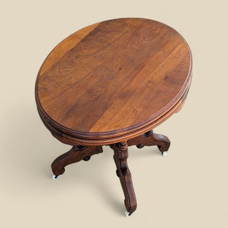 Victorien Ancienne table de salon victorienne ornée d'un plateau rond en bois sculpté sur roulettes en vente