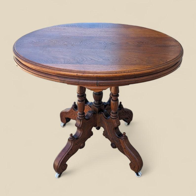 XIXe siècle Ancienne table de salon victorienne ornée d'un plateau rond en bois sculpté sur roulettes en vente