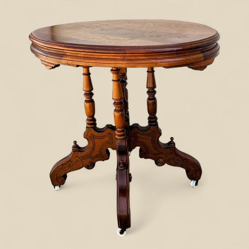 Bois Ancienne table de salon victorienne ornée d'un plateau rond en bois sculpté sur roulettes en vente