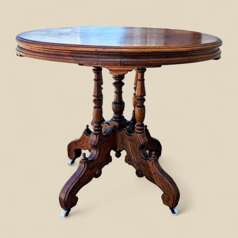 Ancienne table de salon victorienne ornée d'un plateau rond en bois sculpté sur roulettes en vente 1