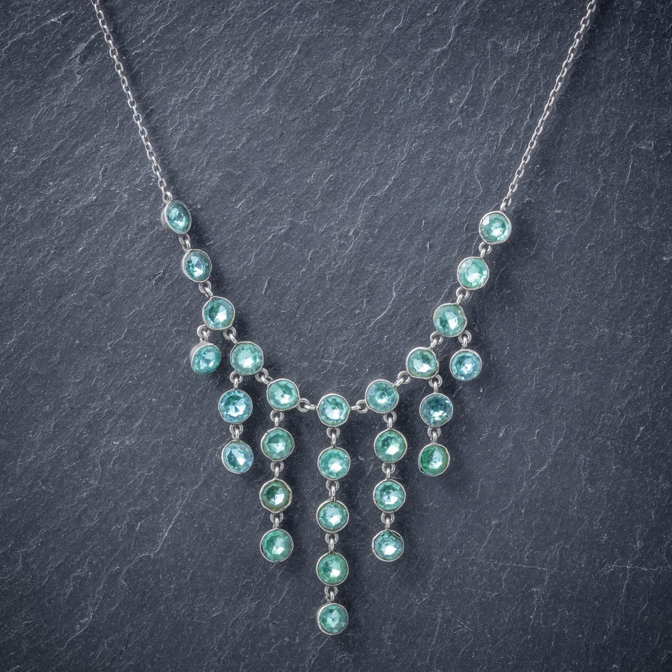 An elegant antique Victorian Lavaliere necklace featuring a row of seven droppers each set with beautiful 0.60ct Paste Stones which have beautiful Teal/ blue colouring similar to that of blue Zircons. 

Each stone is set in Silver and flows into a