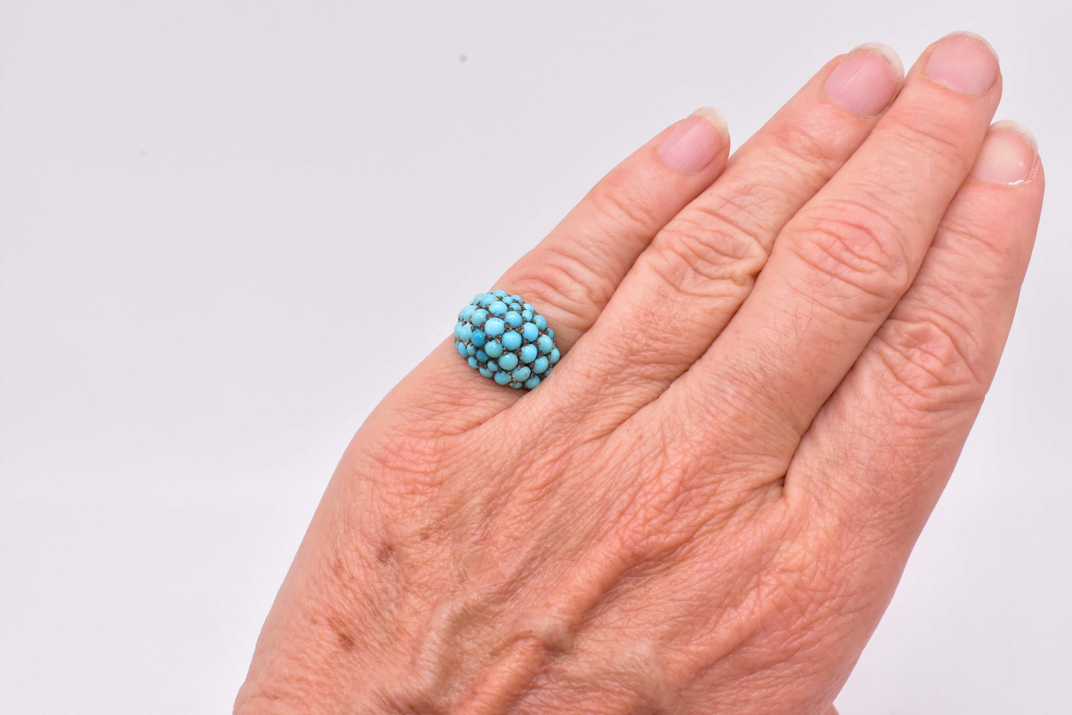 A fine Victorian bombé ring pavé set with turquoise cabochons, with a band of 15k gold and stones set in silver. The turquoise stones are a lovely blue color symbolizing innocence and virtue while the turquoise symbolizes happiness. The ring is