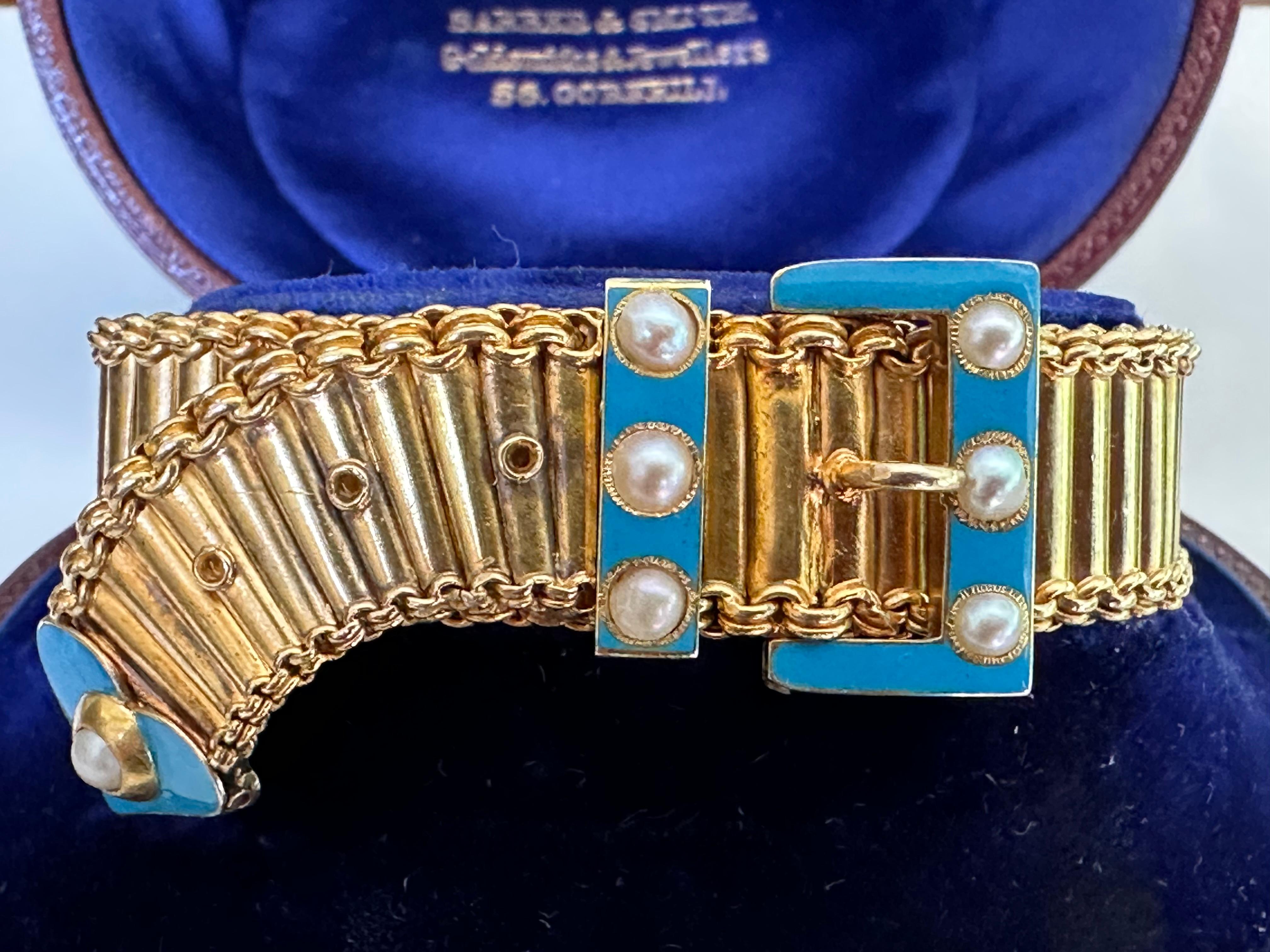 This luxurious antique Victorian 15K yellow gold mesh belt and buckle bracelet is adorned with seven white pearls and light blue enamel. The bracelet comes with its original antique brown leather jewelry box from legendary British goldsmiths and