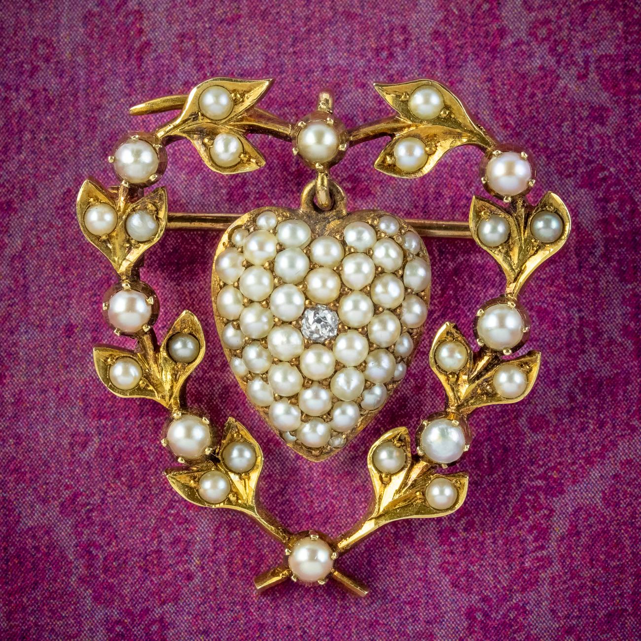 A sweet antique Victorian brooch from the late 19th Century consisting of a heart-shaped wreath decorated with natural seed pearls and a heart suspended in the centre pave set with further seed pearls and a twinkling old mine cut diamond.

Pearls