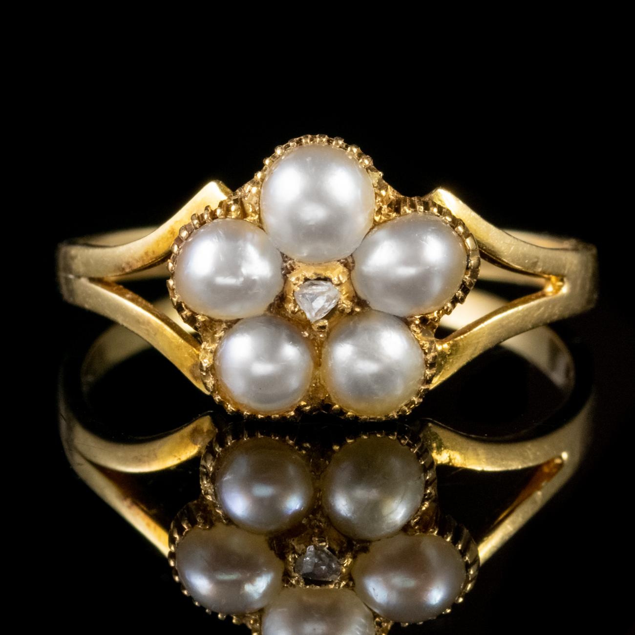 This beautiful Antique Victorian ring has been commissioned in 18ct Yellow Gold and is set with a cluster of five natural Pearls surrounding a 0.07ct Diamond. The stones are set in an ornate milgrain gallery.

The ring also features a locket back