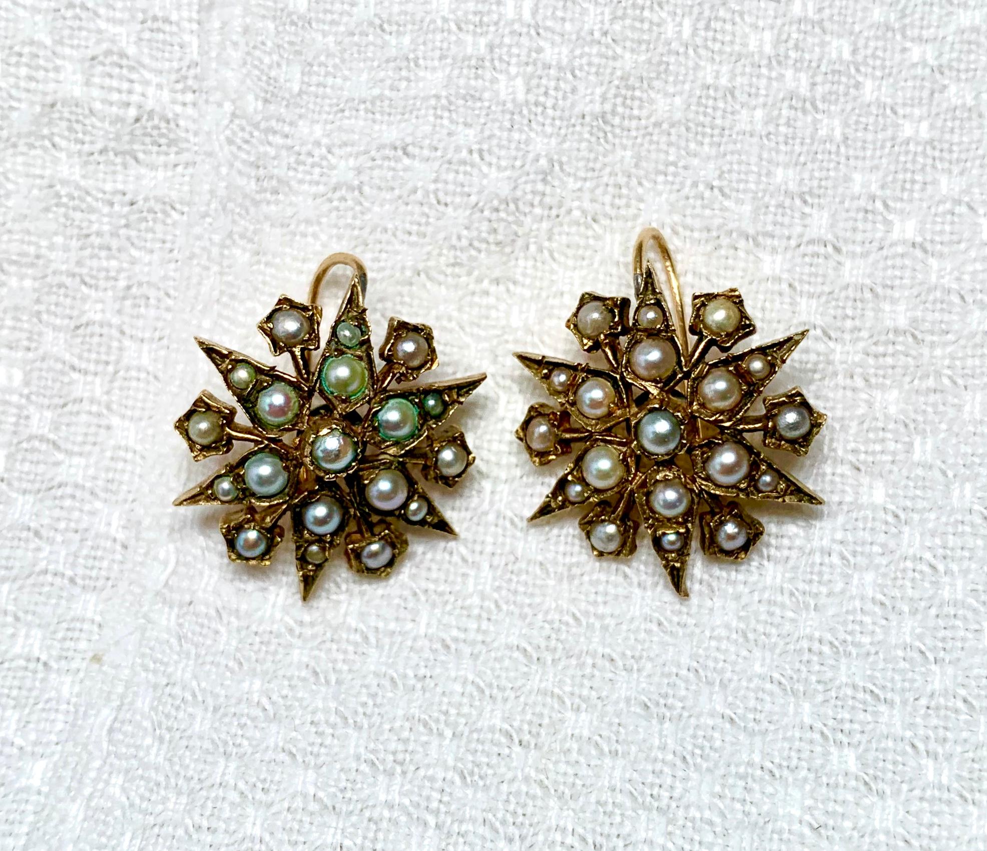 A wonderful pair of early Antique Victorian 14 Karat Gold Pearl Earrings in a star or snowflake motif.  The beautiful earrings are 14 karat gold and are set throughout with silvery pearls.  The gold work is delicate and open work design is very