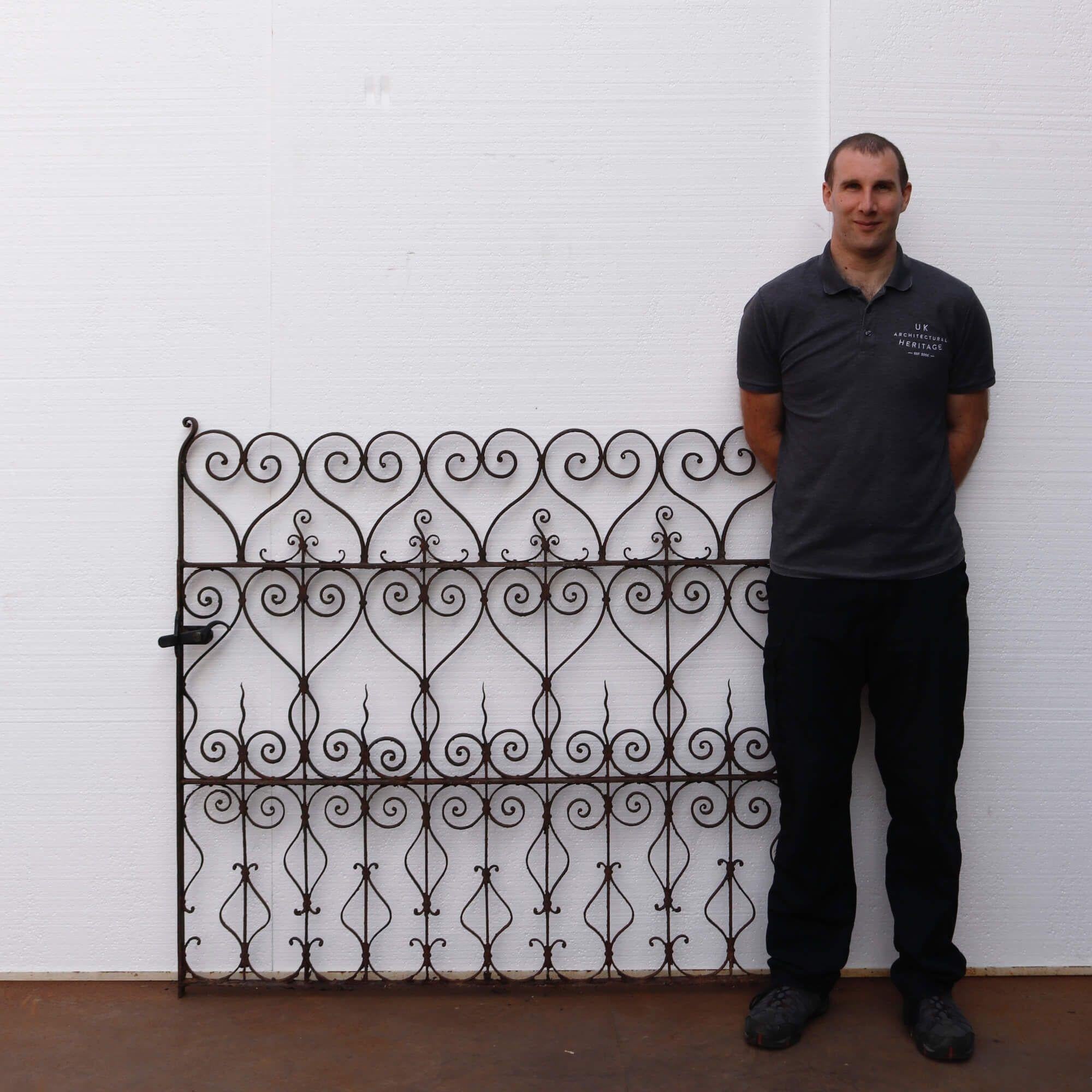 This antique Victorian pedestrian wrought iron gate with scrolling hearts is more than eye-catching. The small waves are another exceptional element to this finely made design. The unusual pattern of this well-crafted gate is accompanied by original