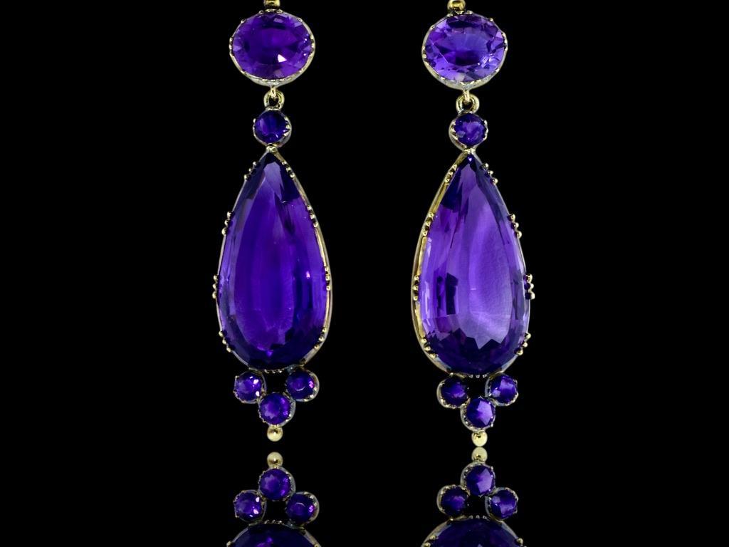 Long and dramatic 19th Century Amethyst Earrings. The deep purple natural amethysts possess an estimated 68 cts of fine well matched amethysts. The long pear cut stones weigh an estimated 28 cts. each. These earrings are in fine condition, and are