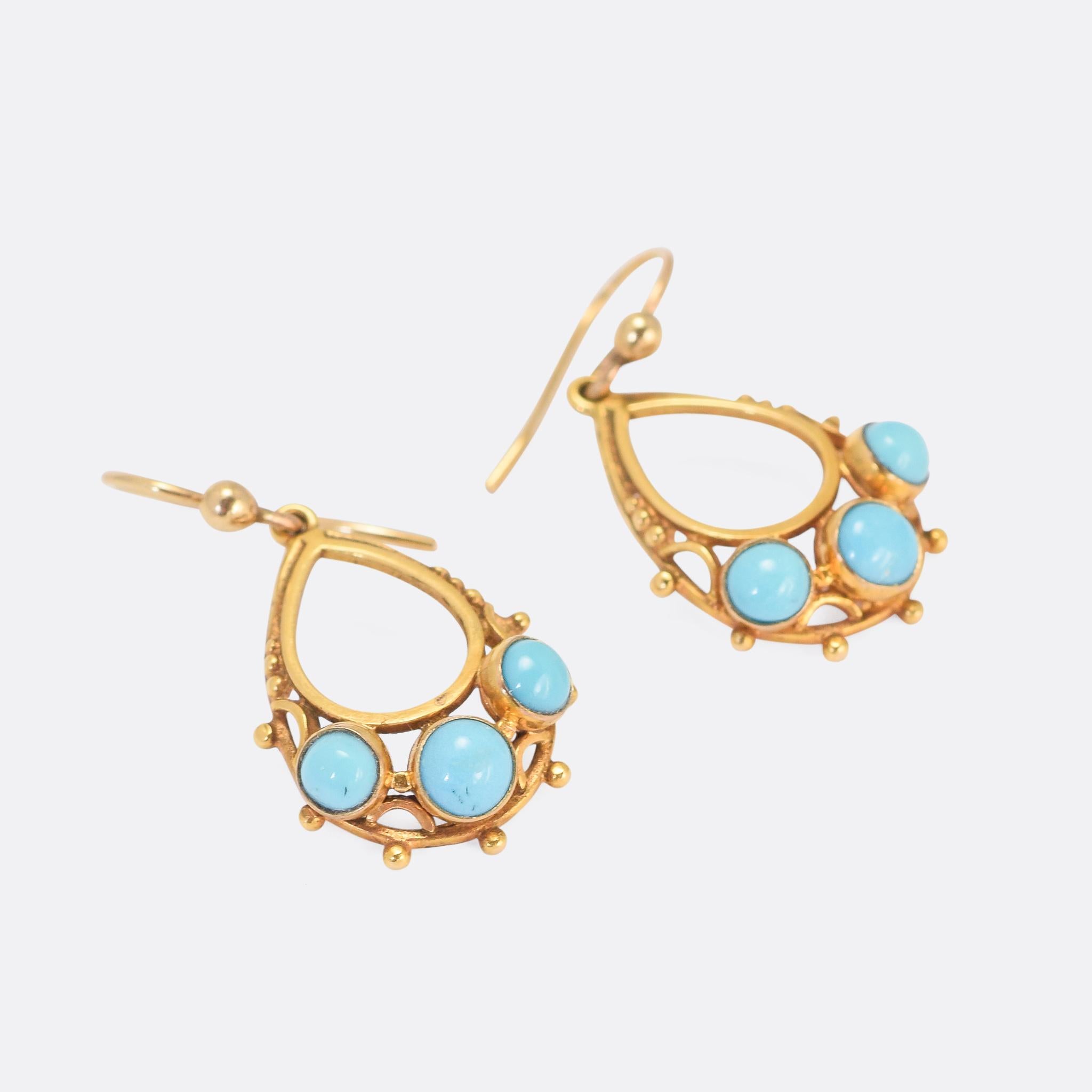 A pretty pair of antique turquoise earrings dating from the latter half of the 19th Century. They're teardrop shaped, each one set with three Persian turquoise cabochons and featuring fine goldwork in the form of applied beading and openwork.