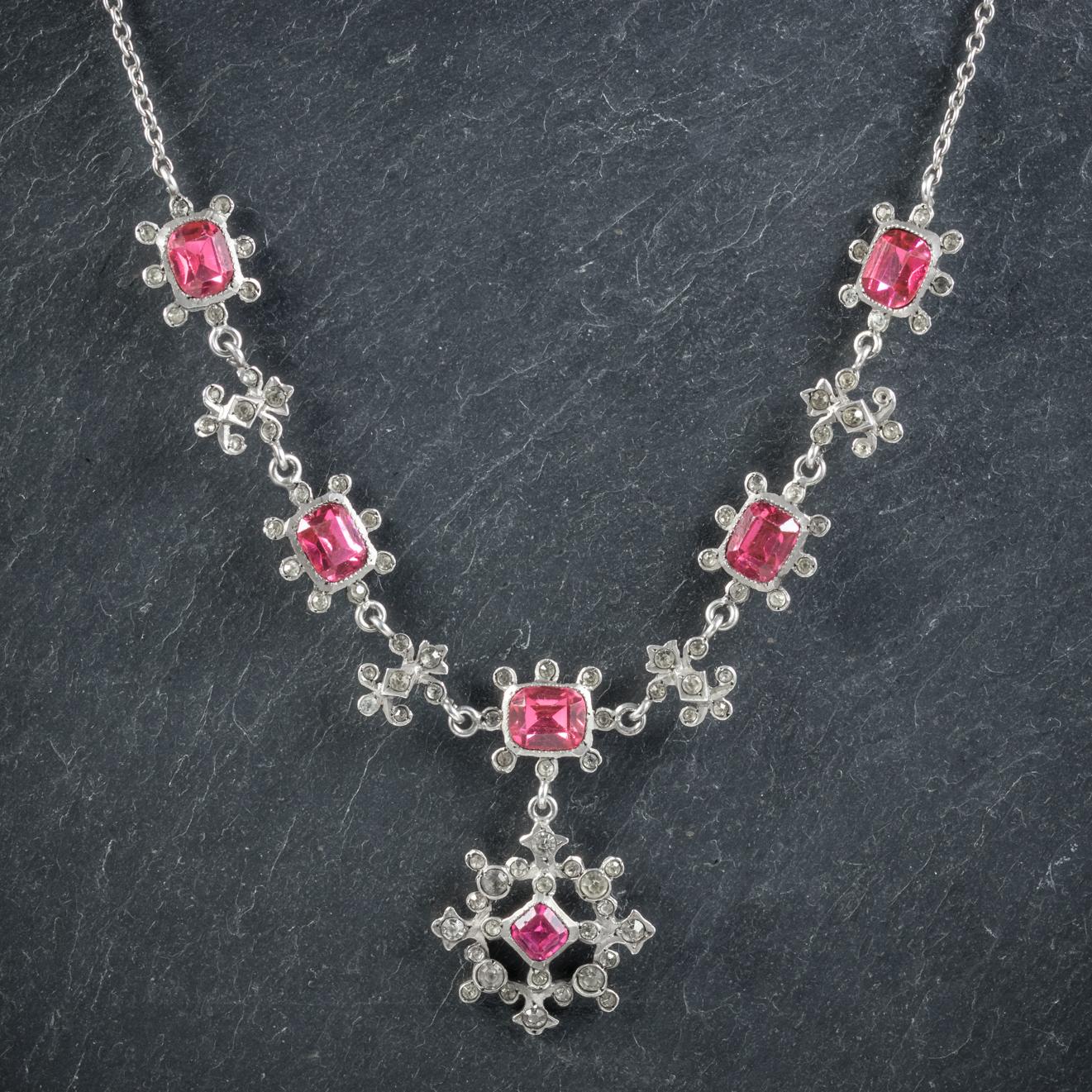 This pretty antique Sterling Silver pink Paste necklace is Victorian, Circa 1900. 

The lovely necklace features nine beautiful Silver links and a fancy dropper adorned with ruby pink Paste Stones and smaller white Pastes that sparkle like Diamonds.