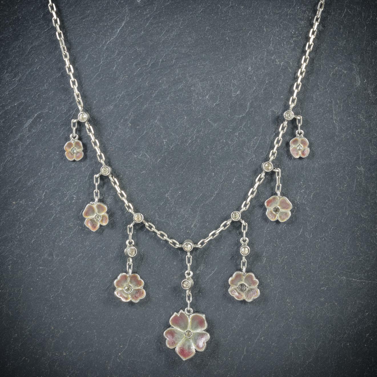 This fabulous antique Victorian, Plique a Jour flower necklace is Circa 1900

Each of the seven colourful flowers is made from Plique a jour Enamel and topped with glistening Paste stones above and in the centre

The chain is complete with -900-