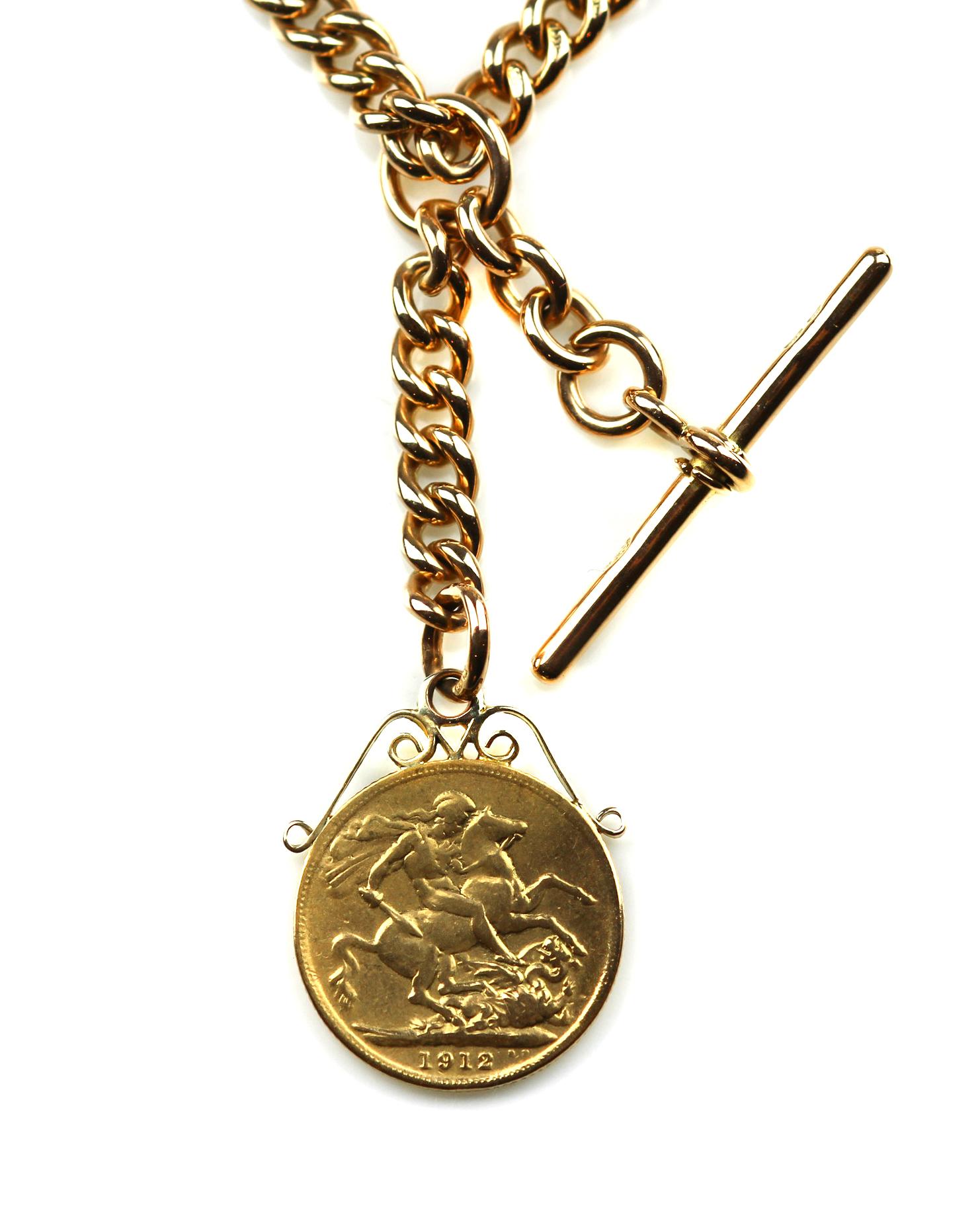 An 18 carat gold chain link necklace suspending a full gold sovereign coin dated 1912. The reverse of the sovereign coin depicts King George V in profile, the front shows St George slaying a dragon from his horse. Beside the sovereign pendant, the