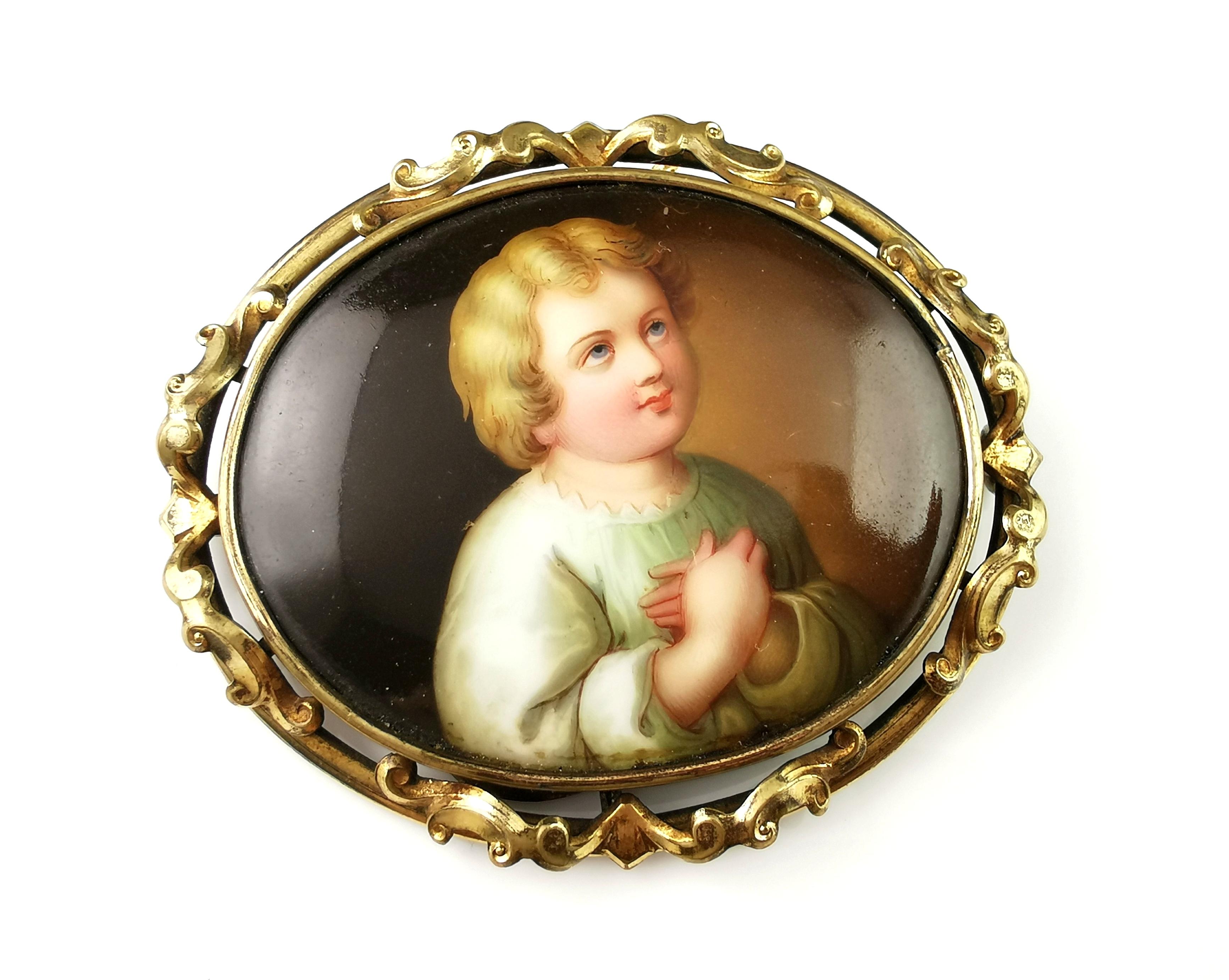 A fine antique Victorian era hand enamelled porcelain brooch.

The brooch is an oval shape with a hand painted porcelain plaque to the centre featuring an angelic child or a Putti.

It is housed in a decorative gilt bronze mount and has an old c