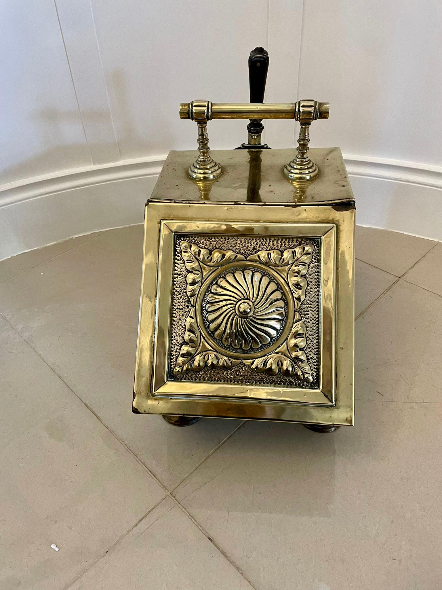 Antique Victorian quality brass coal scuttle having a quality brass embossed lift up lid opening to reveal a storage compartment for coal, pretty ornate brass carrying handle with the original brass shovel and raised on four brass feet 

Measures: