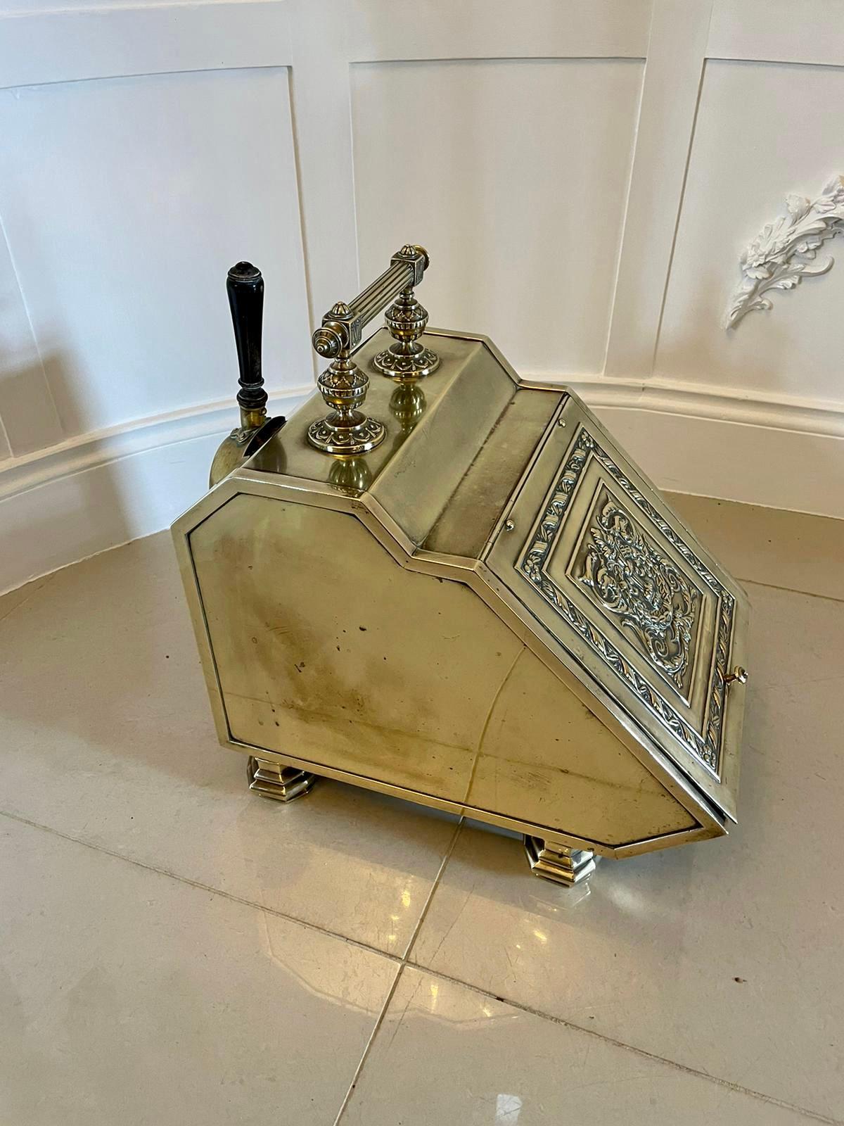 Antique Victorian quality brass coal scuttle having a quality ornate brass lift up lid opening to reveal the original liner, carrying handle to the top with brass shovel and raised on brass feet. 

H 44cm
W 30cm
D 43.5cm

Date 1860.
 