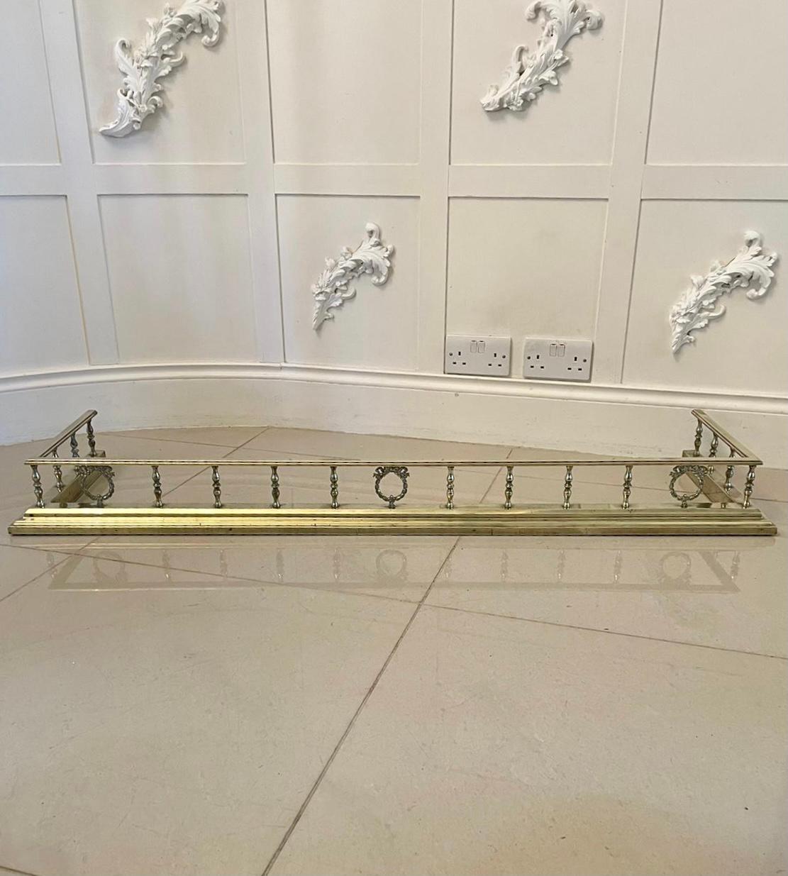 Antique Victorian quality brass fender having a quality brass reeded top above eighteen brass columns and three ornate brass wreaths and bows raised on a stepped brass base.

Measures: H 3 x W 133.5 x D 36.5cm 
Inside measurements 
W 122 D