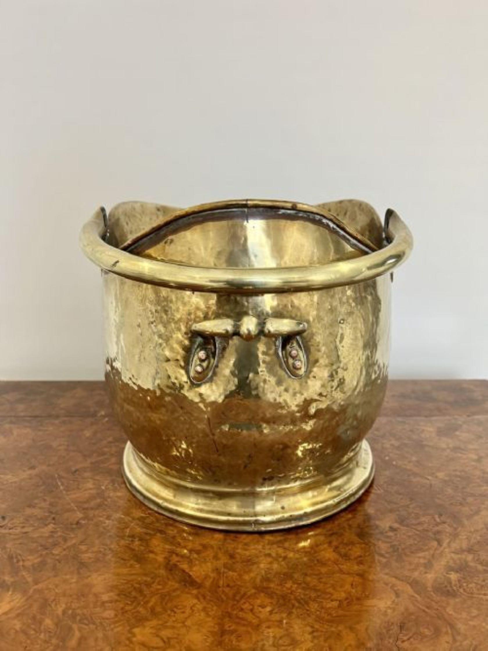 Antique Victorian quality brass helmet coal scuttle having a shaped carrying handle with a shaped quality brass helmet coal scuttle 