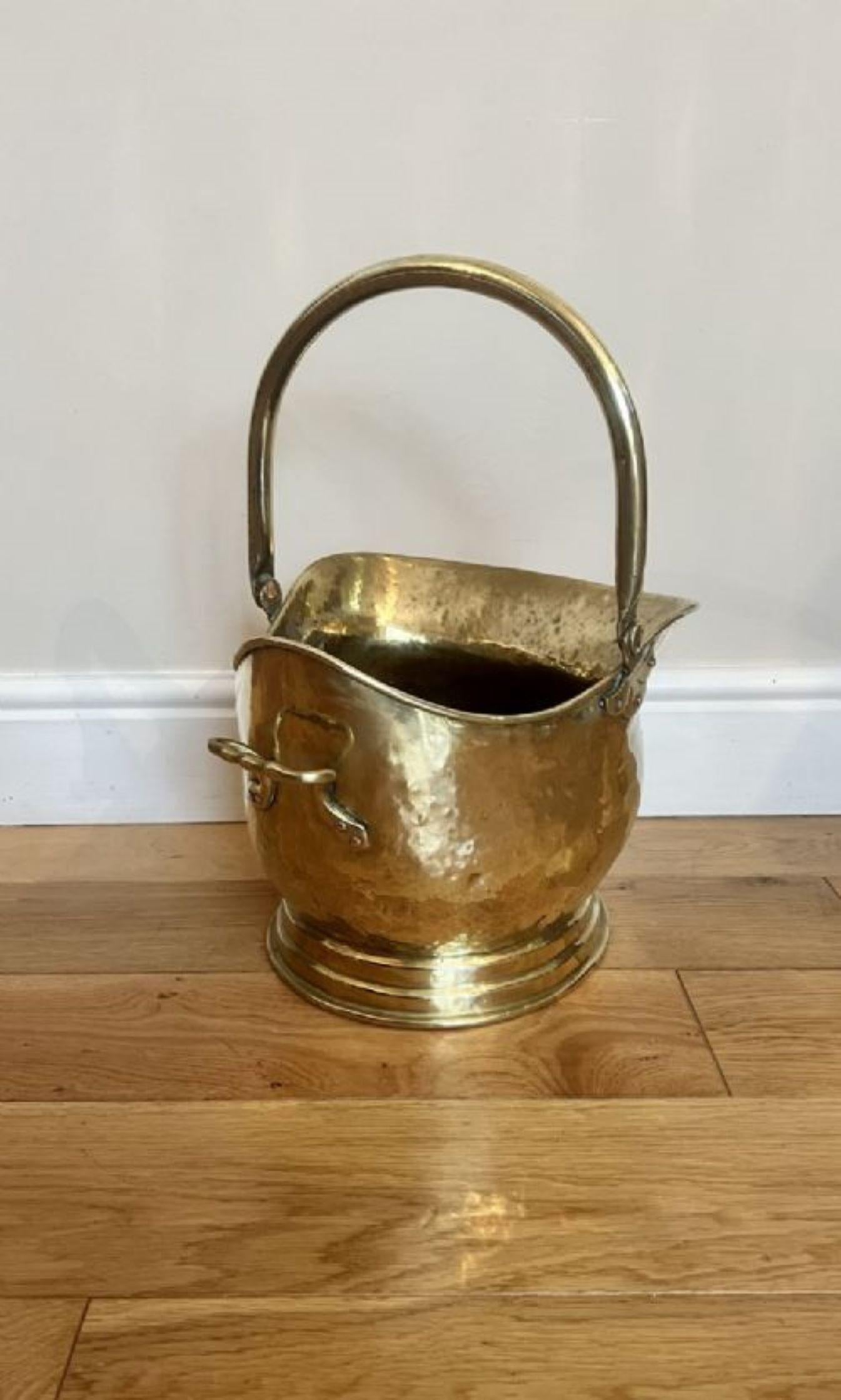 Antique Victorian quality brass helmet coal scuttle having a shaped movable carrying handle with a shaped quality brass helmet coal scuttle and a handle to the back 