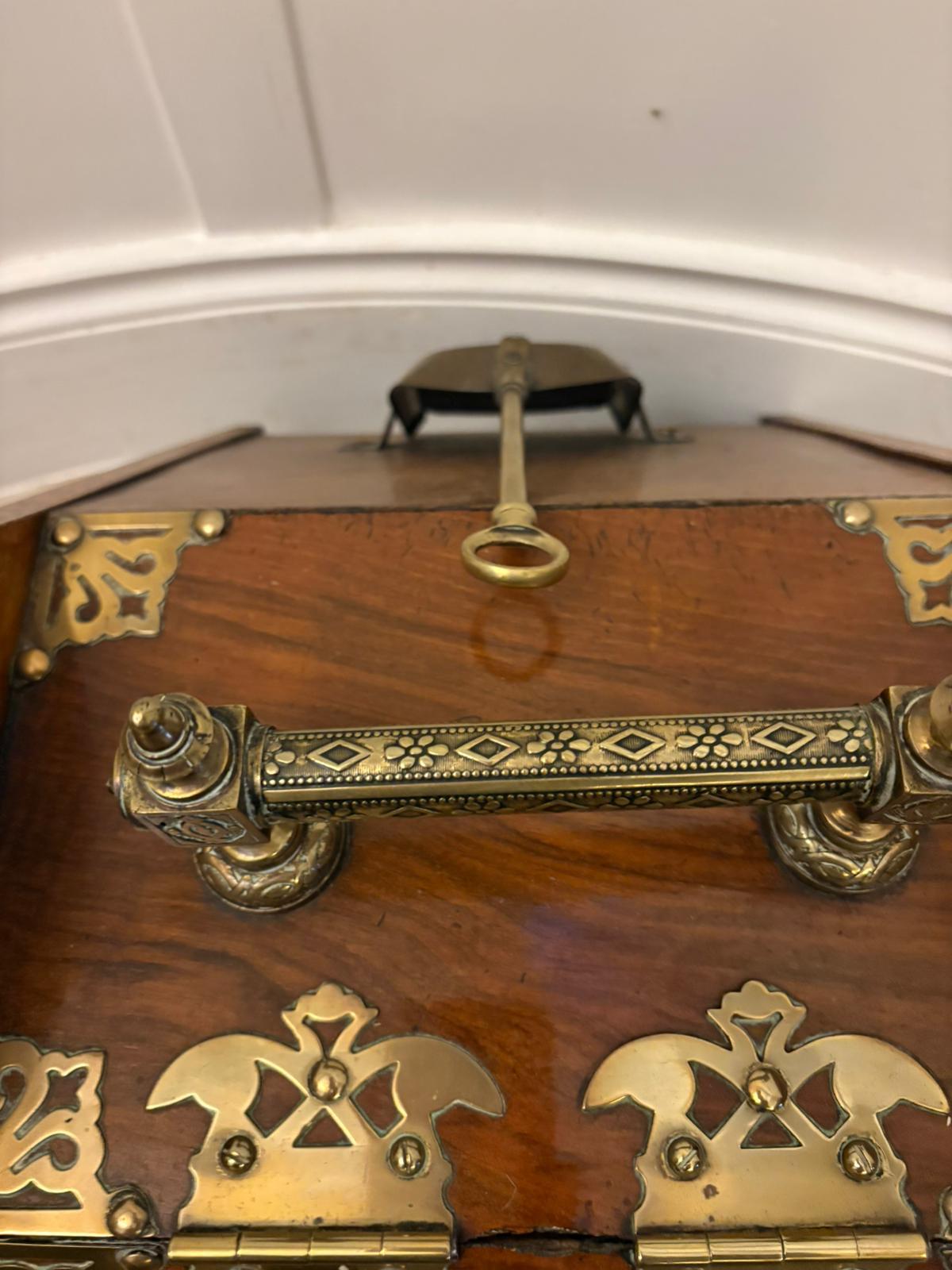 A fine Victorian coal scuttle beautifully made in richly figured walnut with decorative pierced brass mounts. The shaped body features brass strapwork detailing and side panels with attractive grain patterning. The hinged lid lifts to reveal a clean