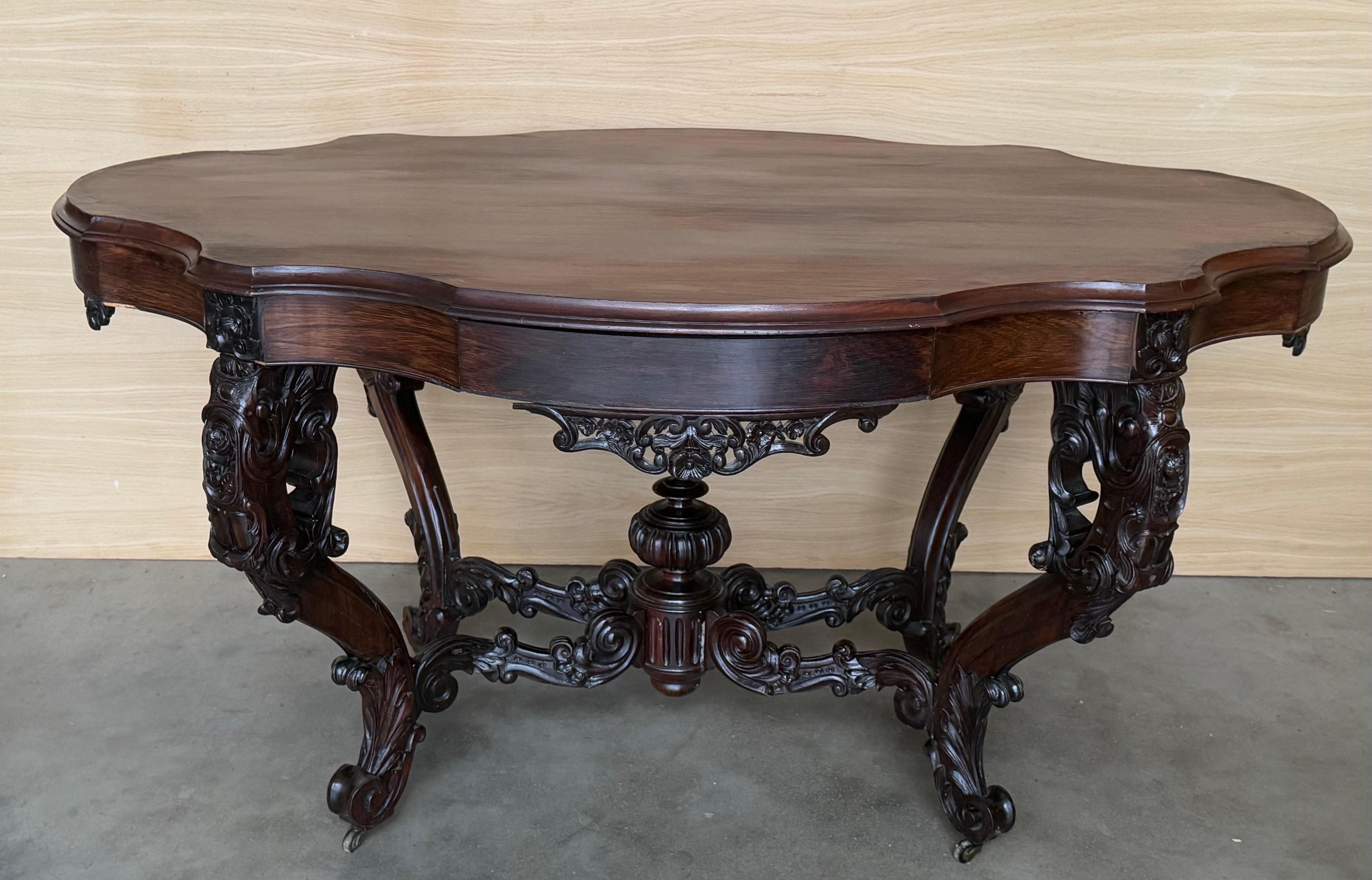 Table centrale victorienne ancienne en ronce de noyer avec un plateau en forme de serpentin en ronce de noyer avec un bord mouluré au pouce, une frise en forme de serpentin soutenue par quatre pieds en noyer massif tournés et sculptés, reposant sur