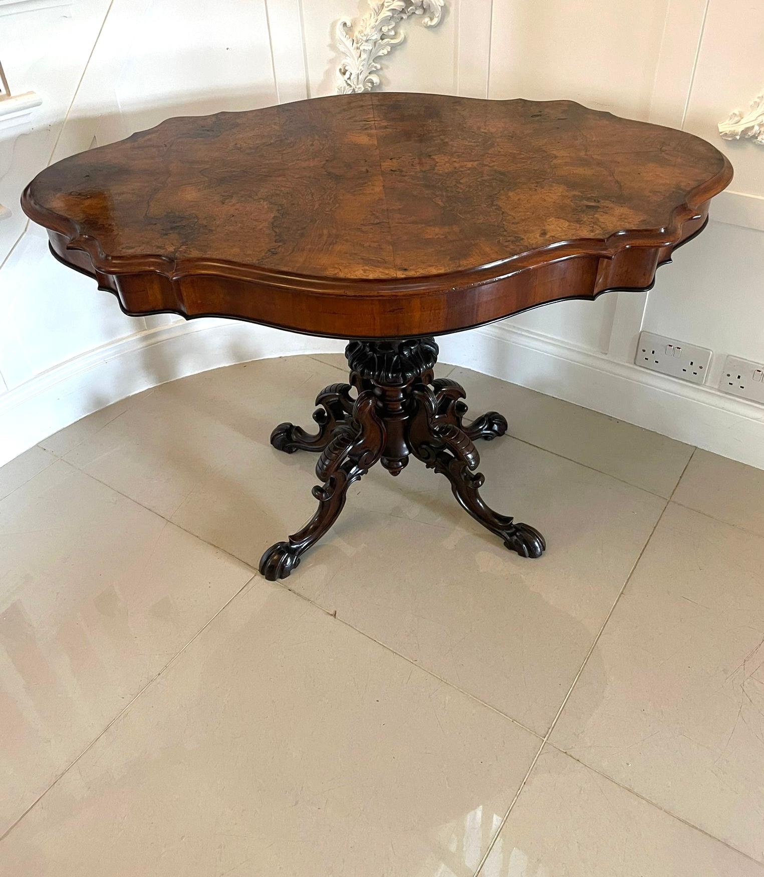 Antique Victorian quality burr walnut centre table having a quality burr walnut serpentine shaped top with a thumb moulded edge, serpentine shaped frieze supported on a turned carved solid walnut pedestal column standing on four shaped carved