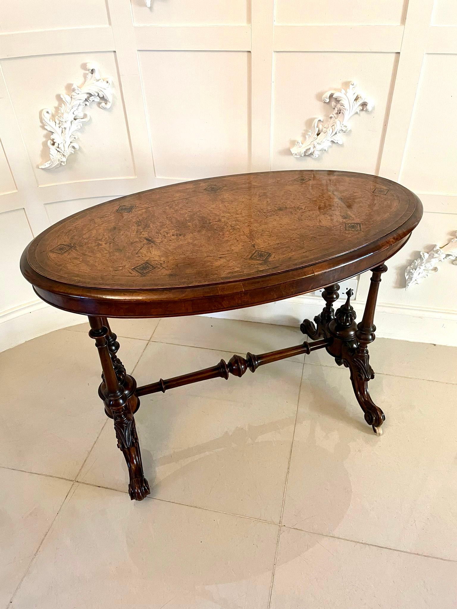 Antique Victorian quality burr walnut inlaid oval centre table having an oval quality burr walnut Tunbridgeware inlaid top with a moulded edge, oval frieze supported by four turned shaped solid walnut columns, carved walnut finials and standing on