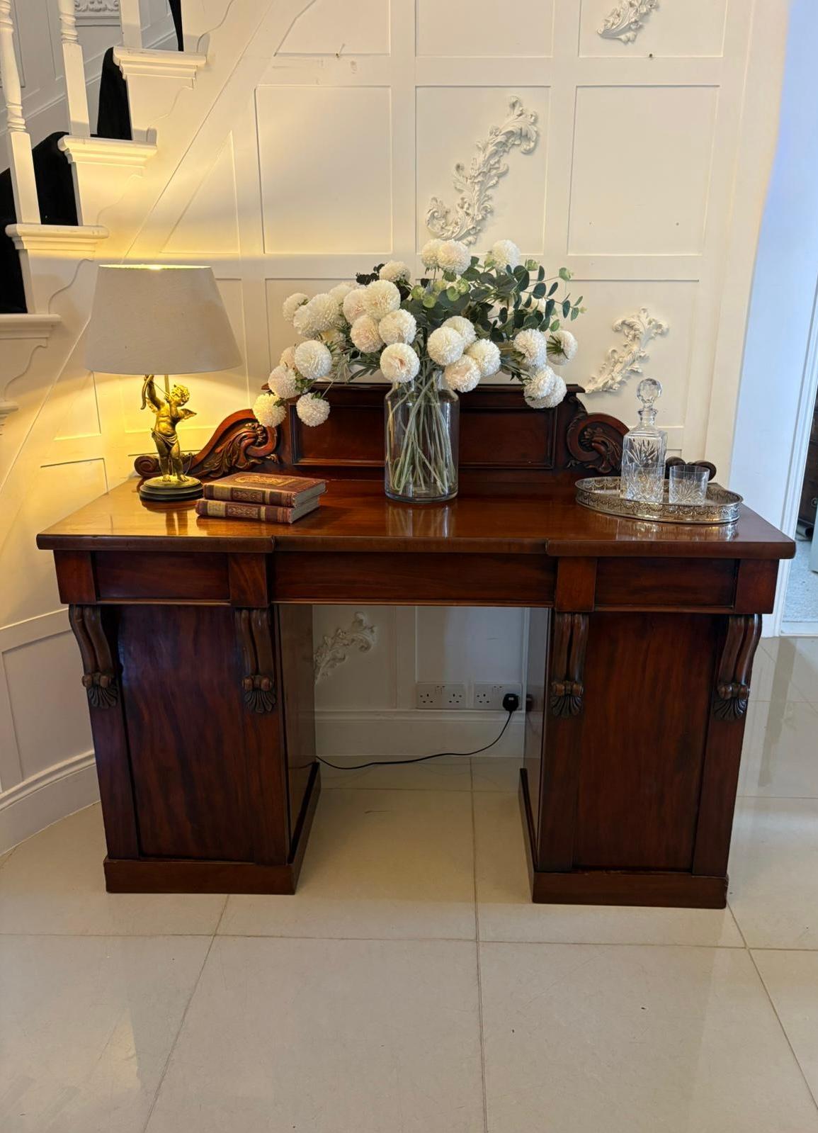 Antique Victorian quality carved figured mahogany sideboard having a quality carved mahogany back above a figured mahogany top, three drawers to the frieze supported by two pedestal cupboards with figured mahogany doors opening to reveal shelves and