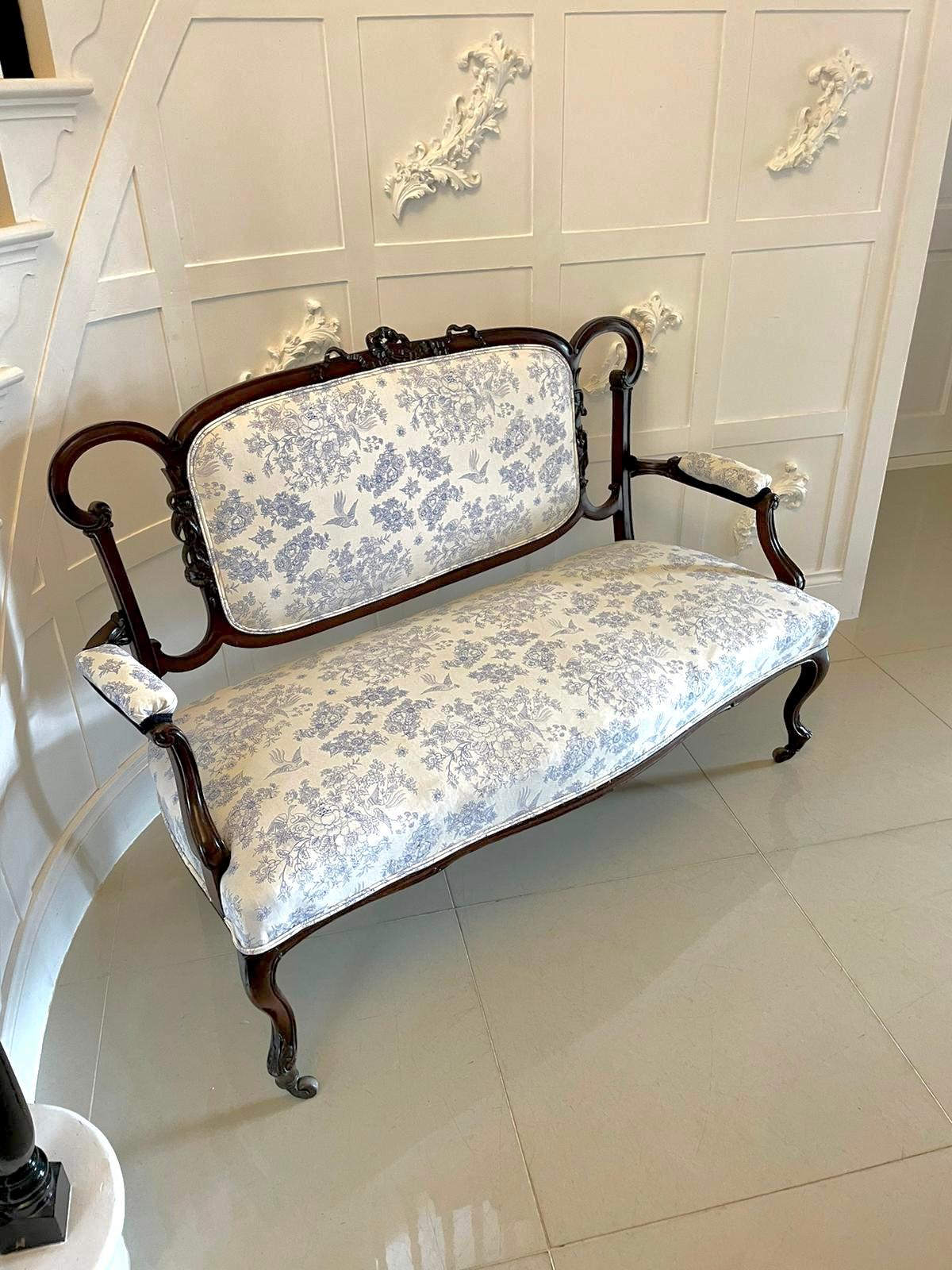 Antique Victorian quality carved mahogany settee having a quality mahogany shaped back with carved ribbons and bows to the top, newly reupholstered in a quality blue and white pretty fabric depicting flowers and birds, shaped carved mahogany open