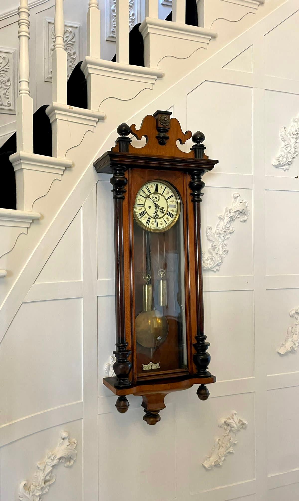 Antique Victorian quality carved walnut Vienna wall clock having a quality carved walnut case with turned columns, original finales, shaped top and bottom, single walnut and glazed door opening to reveal a circular porcelain dial with Roman numerals
