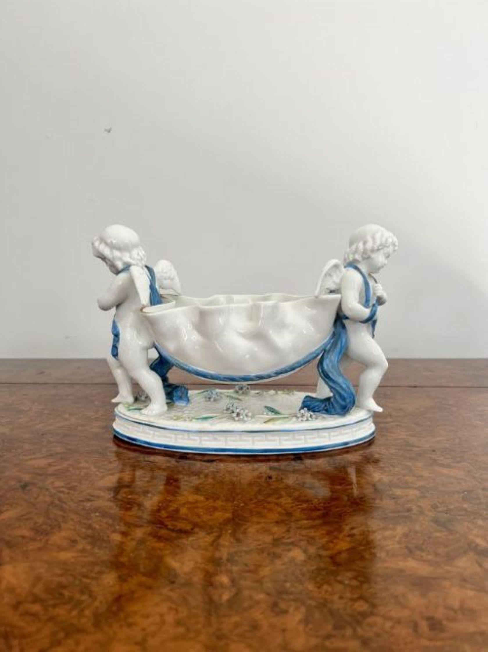 Antike kontinentale Porzellangruppe in viktorianischer Qualität mit zwei Putten, die eine geformte Schale tragen, die auf einem ovalen Sockel steht, in wunderschönen blauen und weißen Farben.
