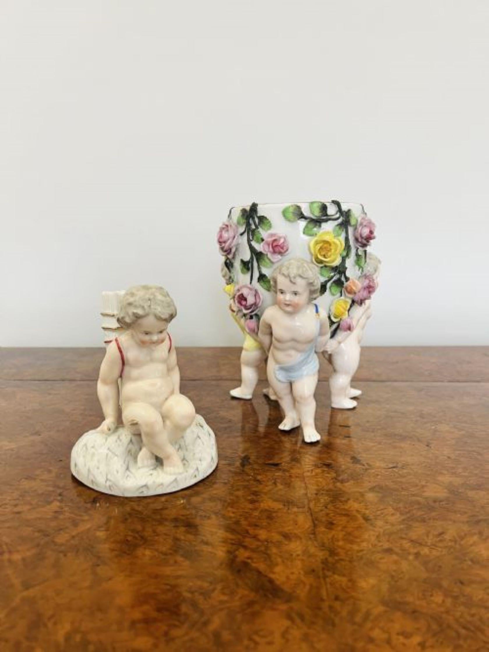 Antique Victorian quality continental porcelain lidded vase having three cherubs raising the vase decorated with pretty leaves and flowers in lovely green, yellow and pink colours with a removable lid with a seated cherub to the top, small chip to