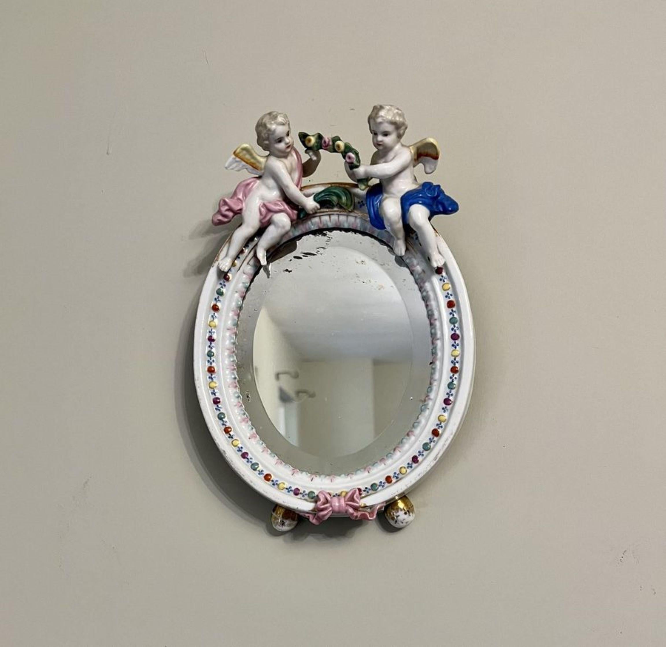 Antique Victorian quality continental porcelain oval mirror having a quality continental porcelain mirror with two cherubs to the top and pink ribbon to the bottom in wonderful hand painted blue, pink, yellow, green, orange, white and gold