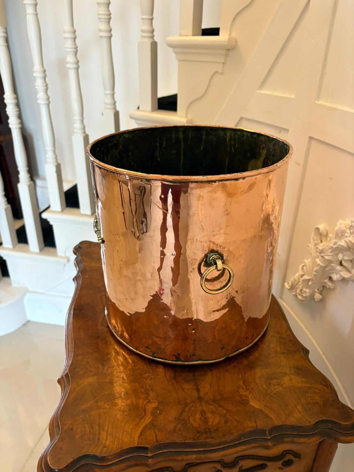 Antique Victorian quality copper and brass coal bin having a circular open copper top with brass ring, carrying handles and brass decoration.

A lovely decorative piece with many uses such as a planter, decorative storage container or umbrella