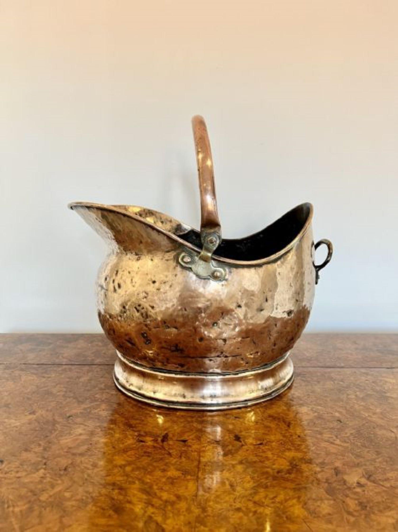 Antique Victorian quality copper helmet coal scuttle having a shaped swing carrying handle with a shaped quality copper helmet coal scuttle and a brass handle to the back 