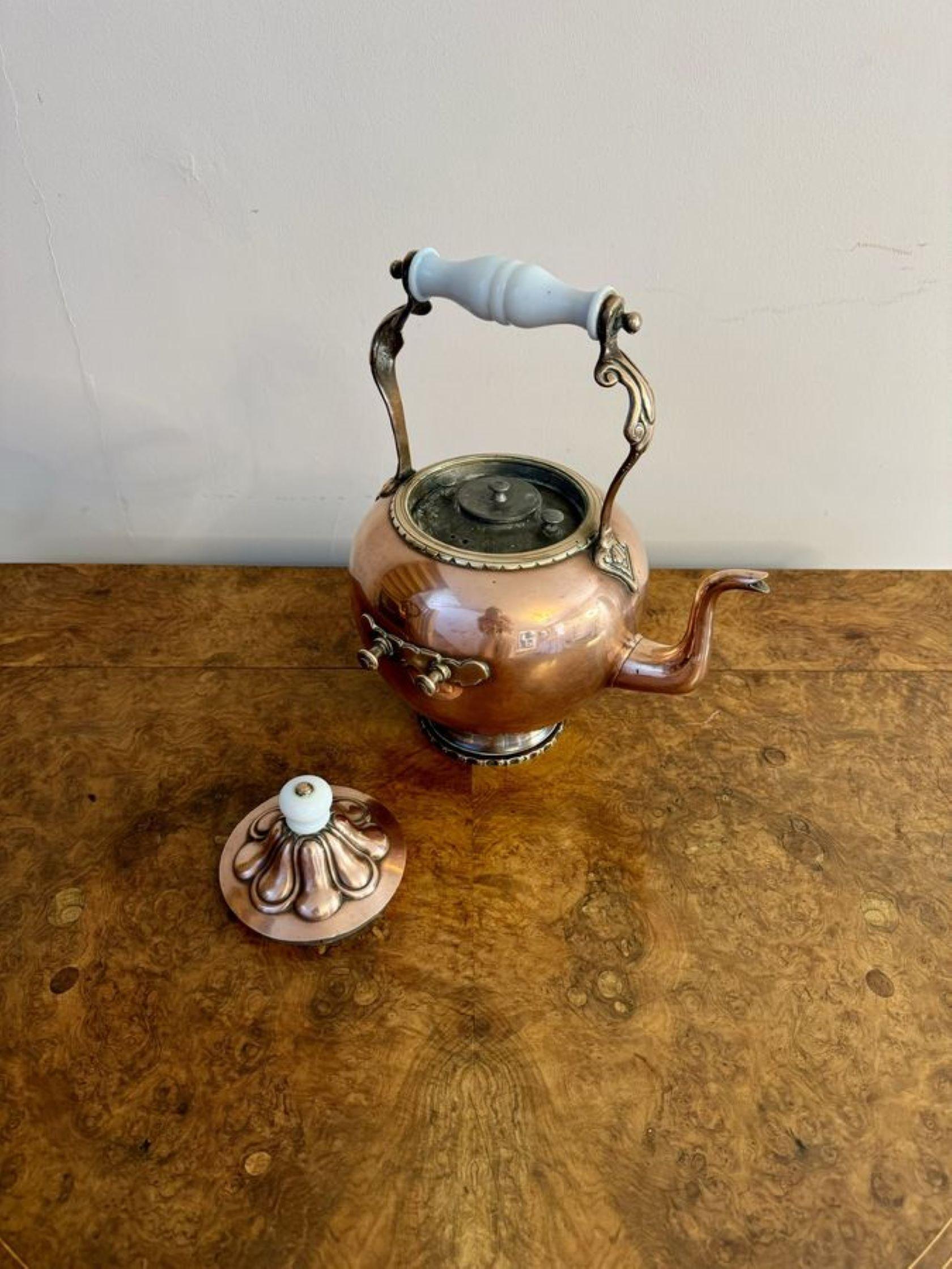 Antique Victorian quality Dutch copper spirit kettle, having a quality copper kettle on a stand with a white shaped handle, standing on the original ornate copper stand with white carrying handles to both sides having the original burner, inset and