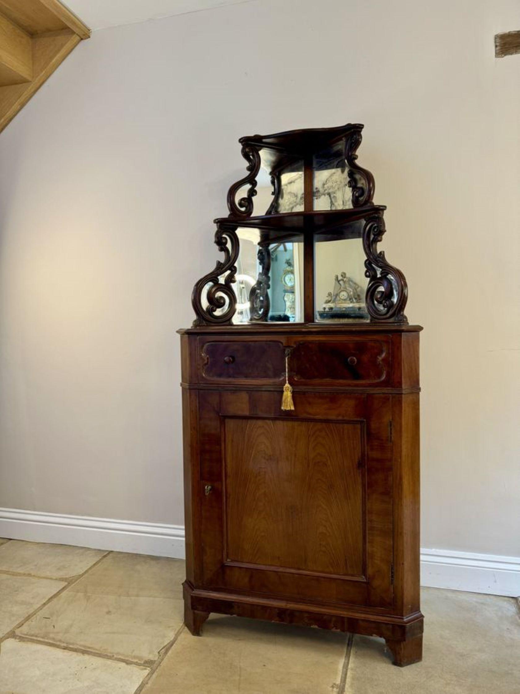 Antique Mirror, mobile angolare in mogano scolpito di qualità vittoriana, con schienale a specchio con volute in mogano scolpito di qualità e due ripiani espositivi sopra un piano in mogano con bordo modanato, un cassetto singolo con maniglia
