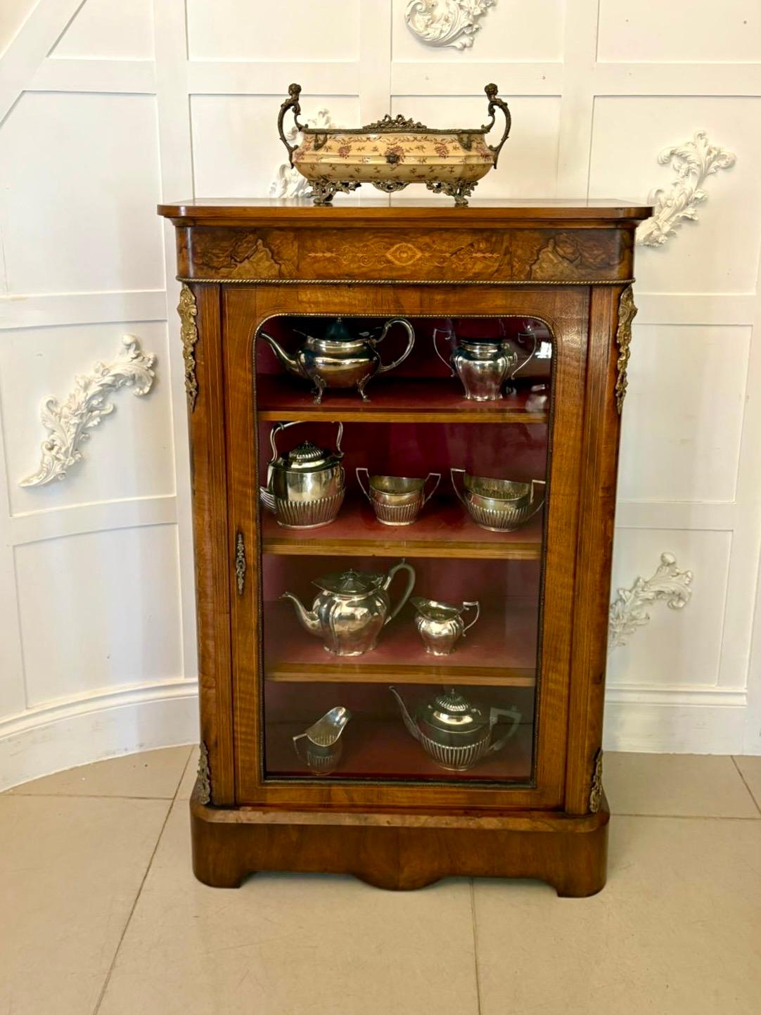 Atractiva vitrina antigua victoriana de nogal con incrustaciones, de elegantes proporciones y altura inusual, que la convierte en una pieza de exposición especialmente llamativa. El mueble está finamente construido en nogal bellamente labrado, con