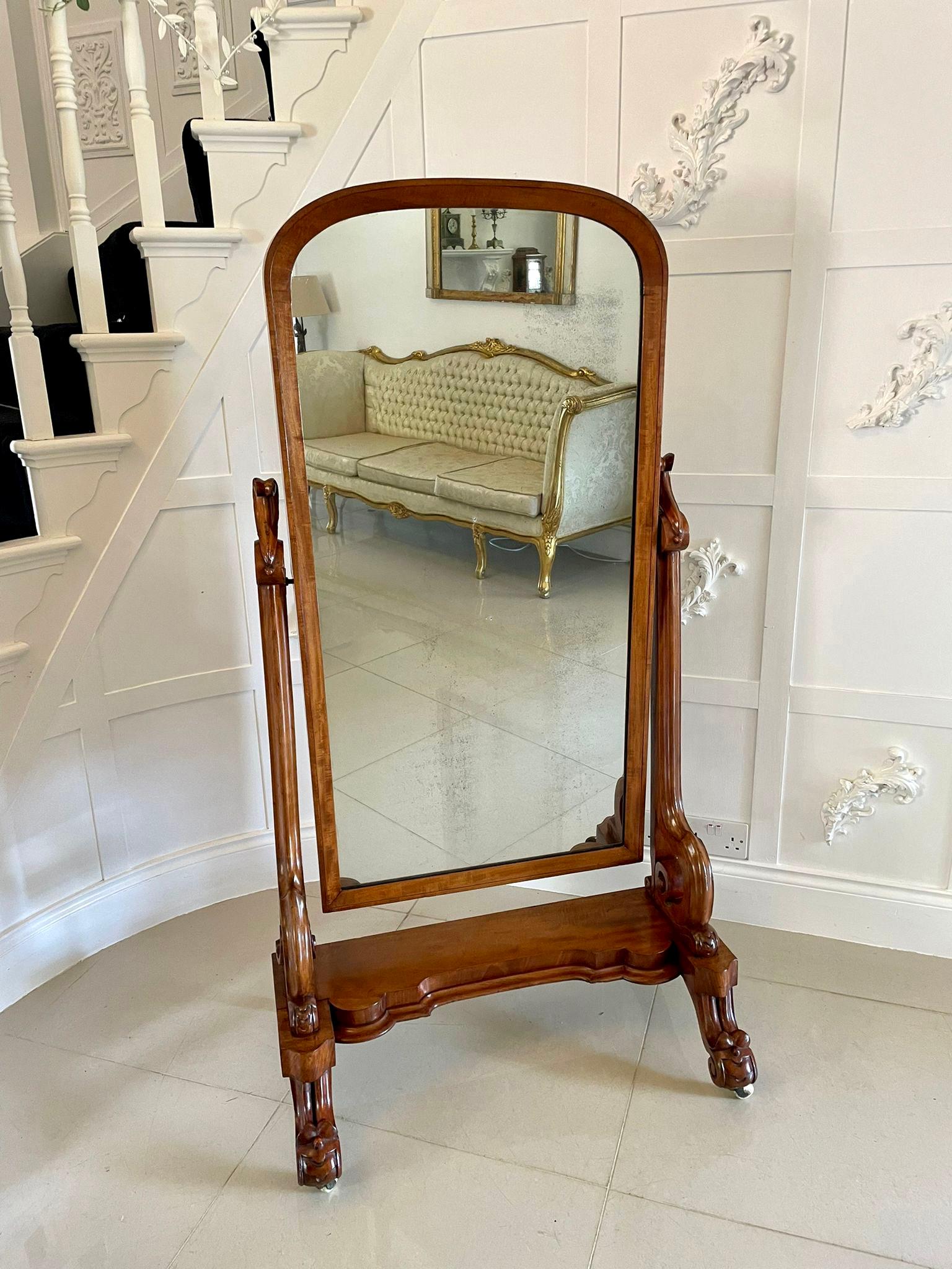 Antique Victorian quality mahogany cheval mirror having a quality mahogany arched top cheval mirror supported by two shaped carved mahogany scroll supports standing on a shaped figured mahogany platform with a moulded edge raised on shaped carved
