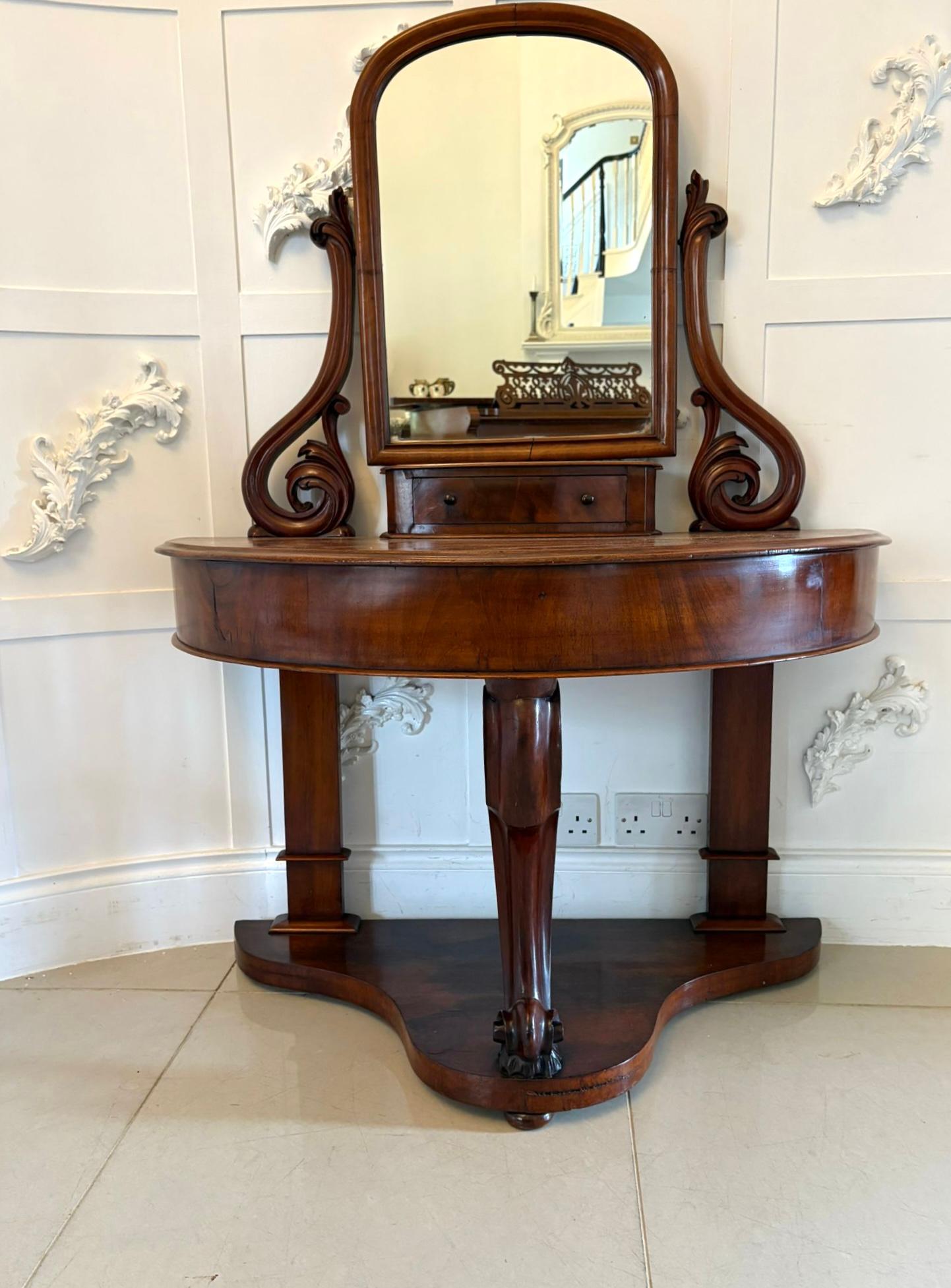 Ancienne coiffeuse en acajou de qualité victorienne comprenant un miroir pivotant réglable soutenu par deux volutes d'acajou sculptées, un tiroir unique avec des boutons tournés d'origine au-dessus d'un plateau en forme de demi-lune avec un bord