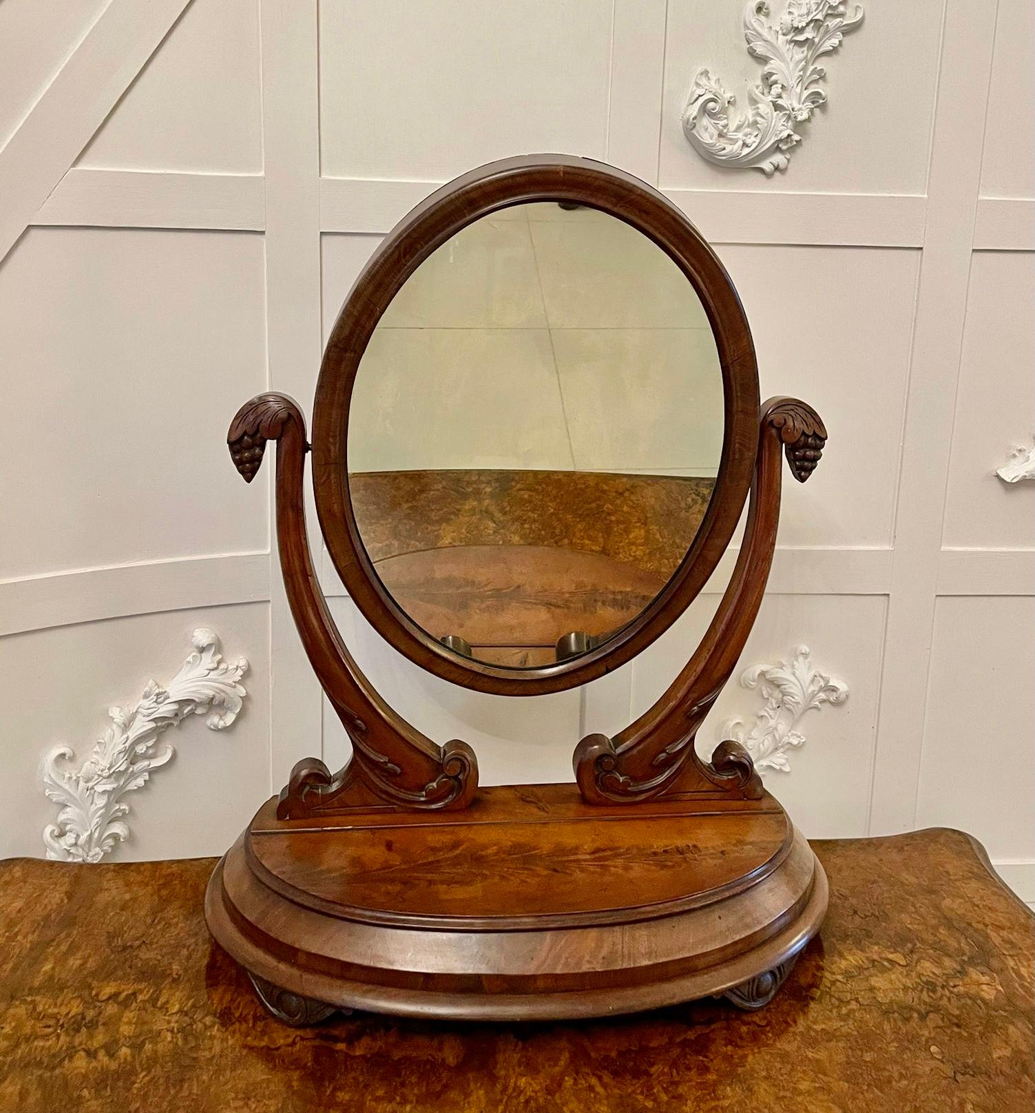 Antique Victorian quality mahogany dressing table mirror having a quality oval shaped mahogany framed adjustable swing mirror supported by two shaped carved mahogany supports raised on a figured mahogany moulded edge base with a lift up lid opening