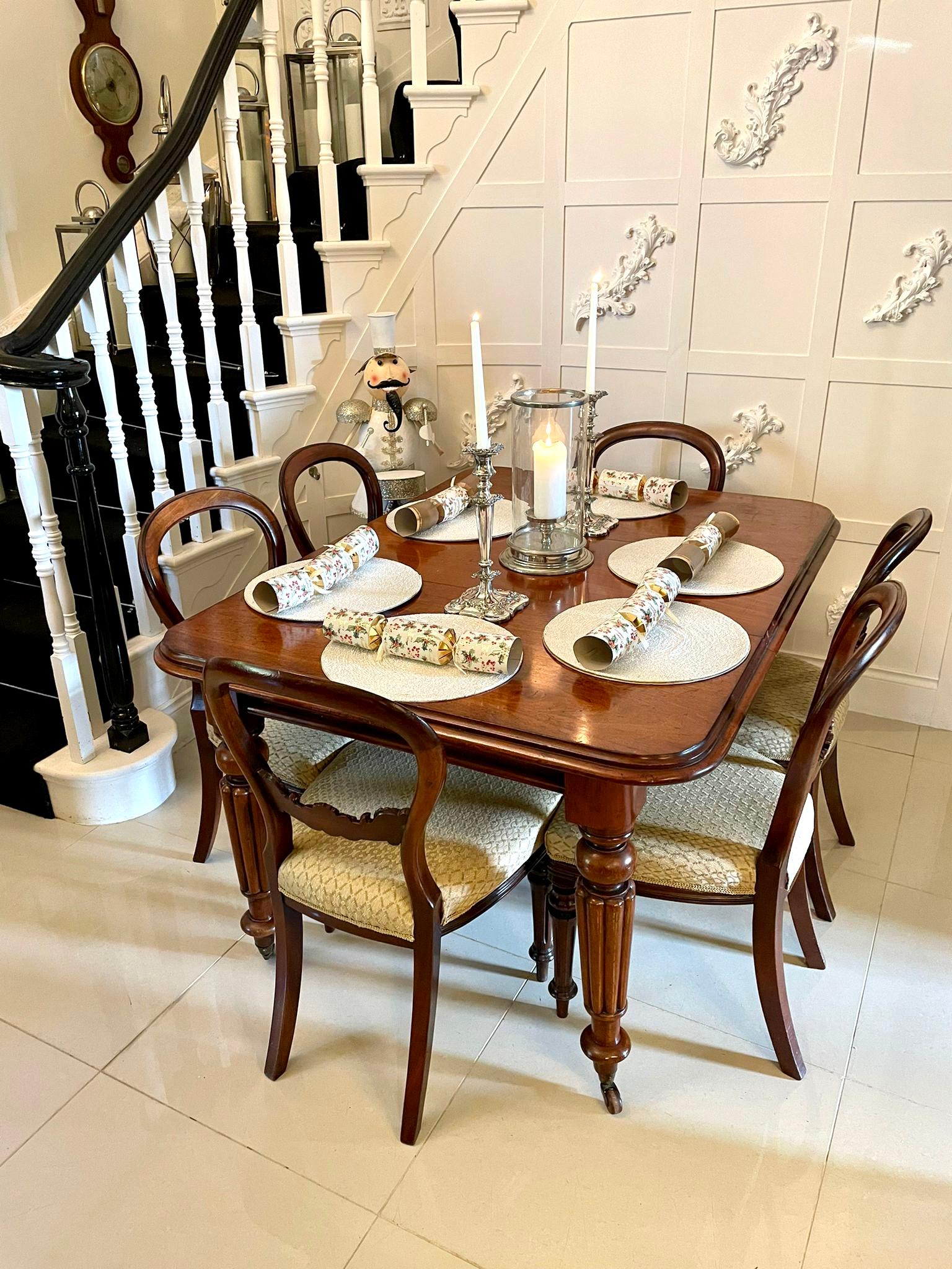 Antique Victorian quality mahogany extending dining table having a quality mahogany double moulded edge and one original extra leaf with original winding mechanism and handle. It stands on four reeded tapering legs with original brass cup castors