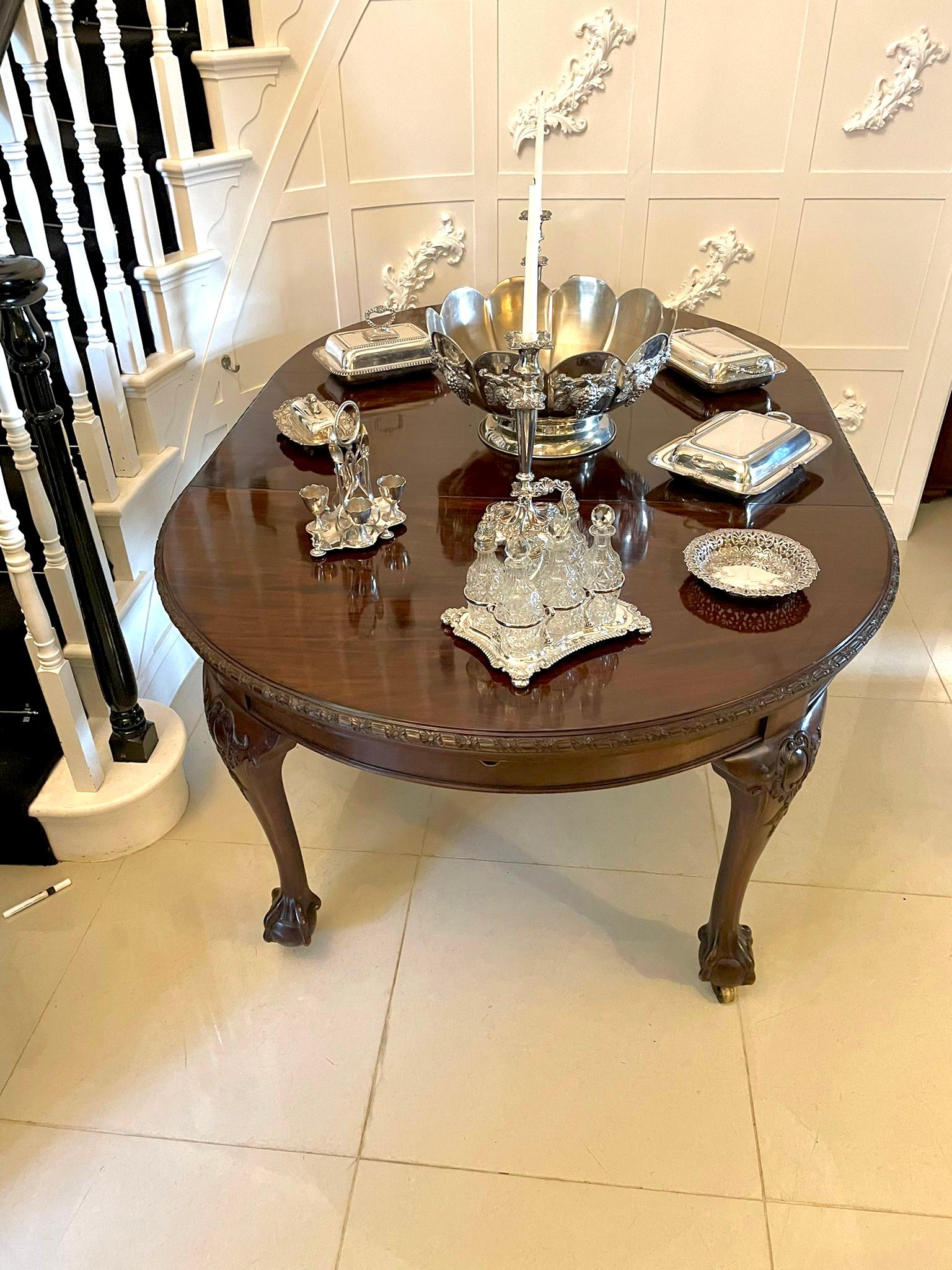 Antique Victorian quality mahogany extending dining table having a quality mahogany circular top with a fantastic carved edge and frieze.  It has one original extra leaf, original winding mechanism and handle and stands on four quality carved shaped