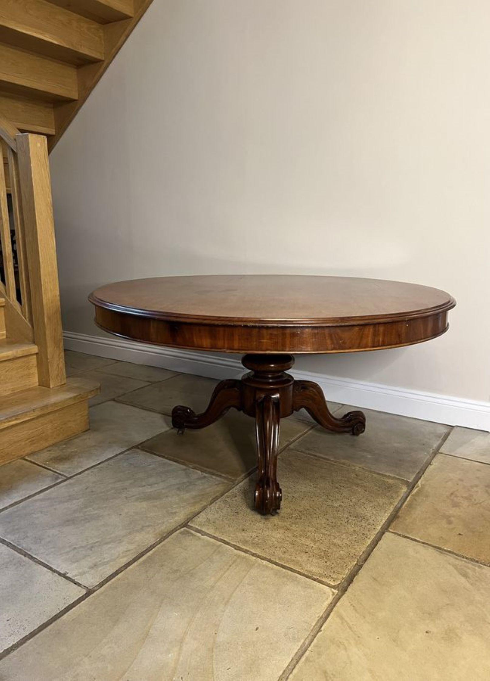Antique Victorian quality mahogany large round dining table having a quality large mahogany circular top with a moulded edge supported on a turned pedestal column, standing on three shaped carved cabriole legs with the original casters.

D. 1860