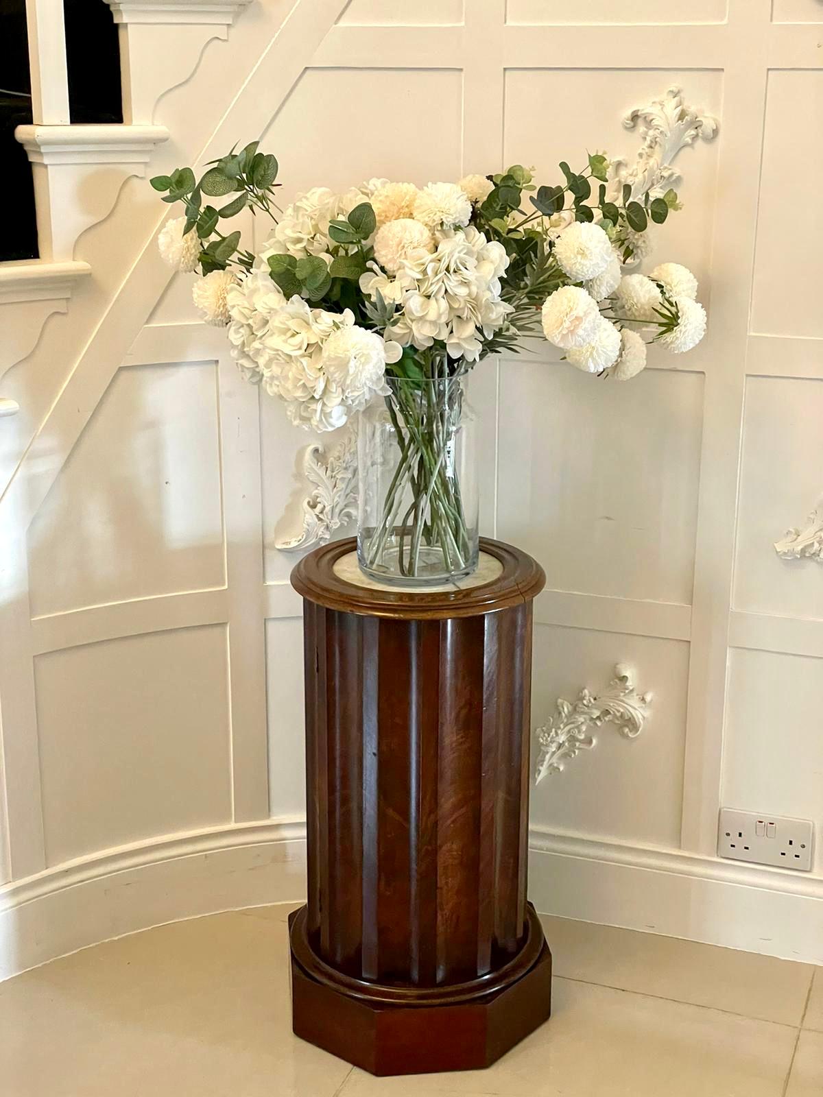 Antique Victorian quality mahogany pedestal cabinet having a circular white marble top with a mahogany frieze above a shaped fluted figured mahogany pedestal with a single door opening to reveal a shelf interior and standing on an attractive