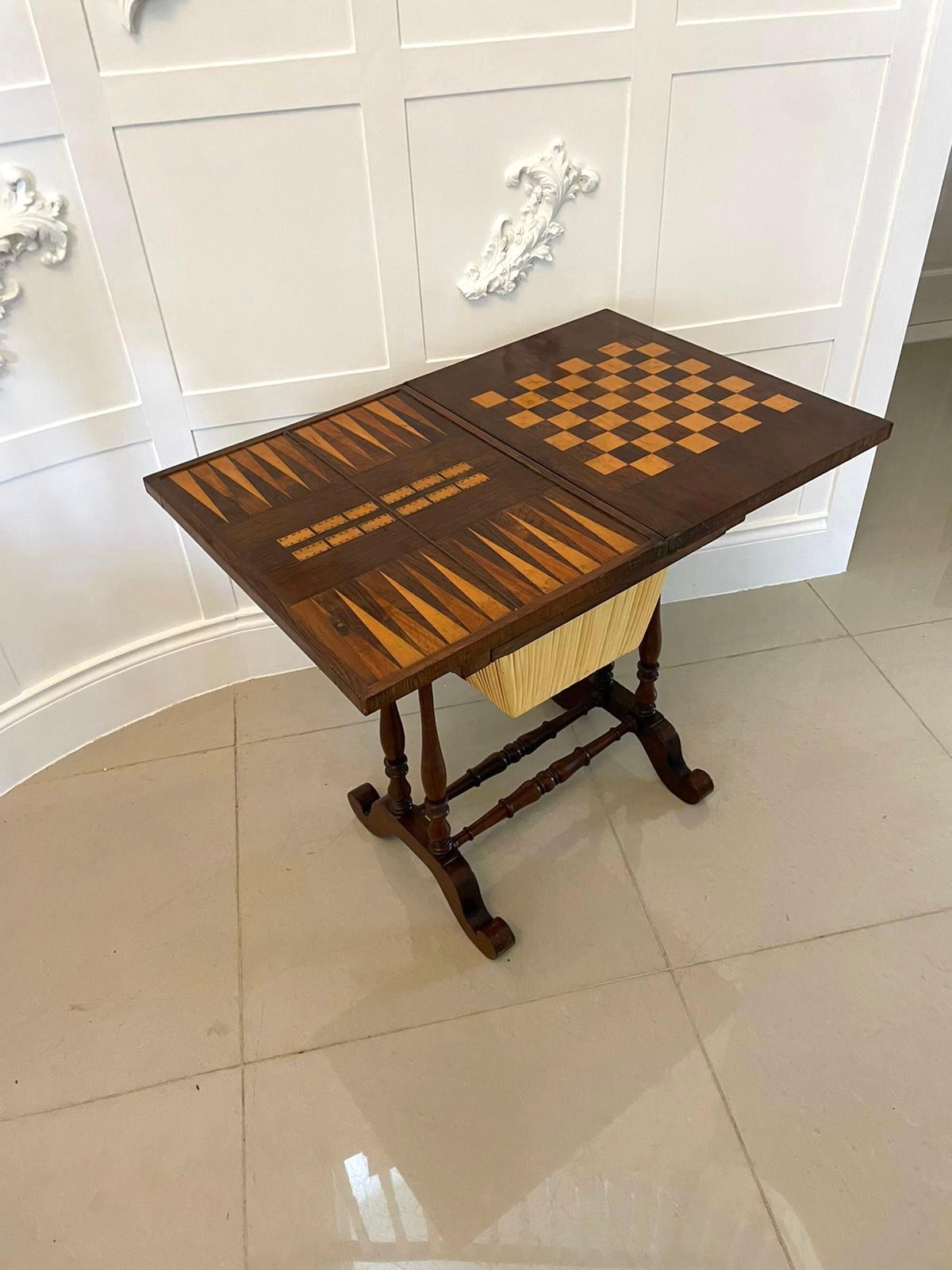 Antique Victorian quality rosewood backgammon/chess games table having a quality rosewood swivel top opening to reveal a backgammon, cribbage and chess board above a frieze drawer and a sliding storage compartment supported on four turned shaped