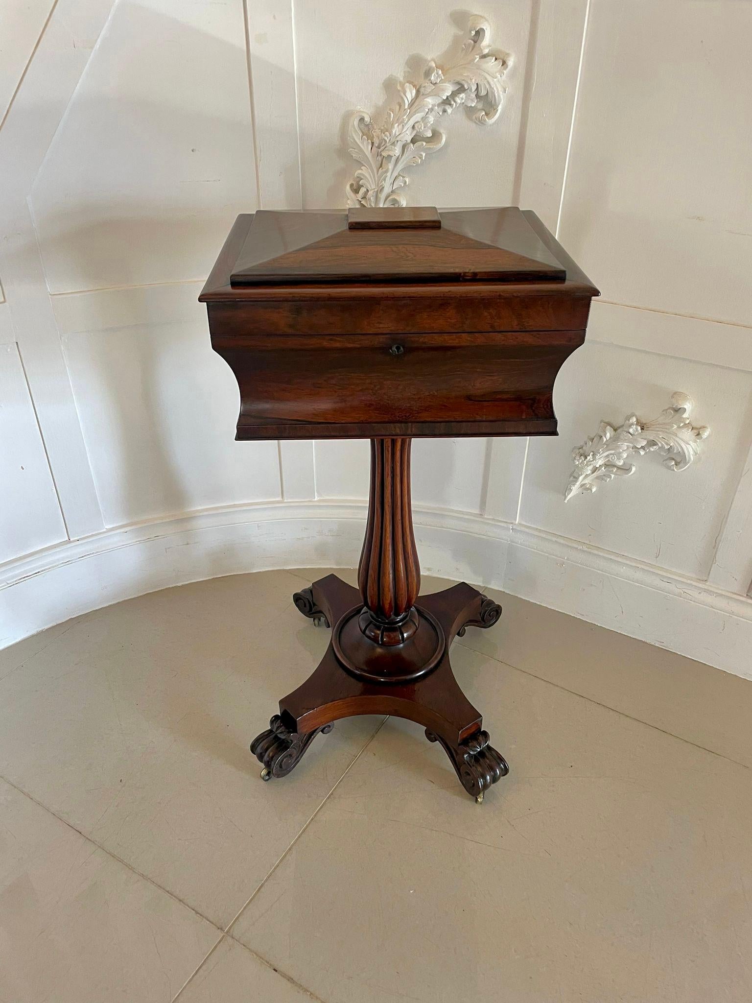 Antique Victorian quality rosewood teapoy having a sarcophagus shaped top with a hinged lid opening to reveal a fitted interior consisting of two tea caddies and two glass mixing bowl raised on a shaped reeded pedestal column and a platform base