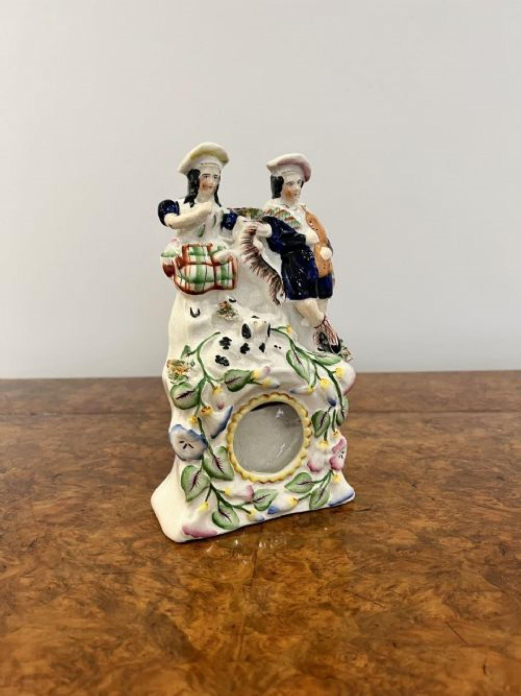 Antique Victorian quality Staffordshire watch holder having a quality antique Victorian watch holder with two figures of a man and a lady to the top with two dogs, to the base wonderful flowers and foliage decorated around a compartment to display a